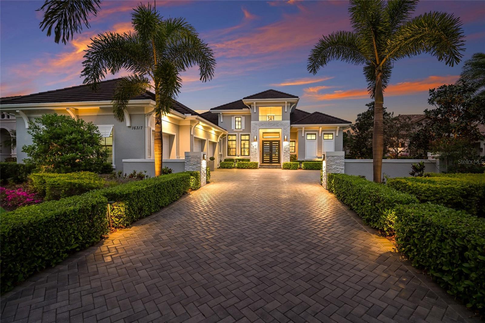 Under contract-accepting backup offers. Curated by an interior designer, this professionally refined residence was built on a stunningly private lot boasting conservation wildlife views in the Vineyards section in the exclusive gated community of The Lake Club.  Encompassing 3,268 square feet of open one-story living, this customized Stock Home exudes stylishly planned indoor and outdoor spaces, accentuated volume ceilings, skillfully selected finishes, the option of a fourth ensuite bedroom, and, of course, all IMPACT windows/doors/sliders. 

A magnificent outdoor living retreat delivers on all fronts with extensive open and under cover spaces grounded with travertine pavers, soaring designer accentuated ceilings, full summer kitchen recently expanded with a wrap around bar, a PebbleTec heated saltwater pool/spa with fire bowls, and a dual sided gas fireplace with surrounding stone. Ten foot disappearing impact glass sliders seamlessly connect the outdoor oasis to a luxuriantly elevated great room, dining area and kitchen crowned with stunning ceiling treatments and designer light fixtures creating a sophisticated and open continuity of space. Meanwhile the kitchen further accentuates with waterfall quartz counters, dovetail soft-close drawers, large walk-in pantry, high-performance Jenn-Air appliances, and even a warming drawer. 

Serenity awaits in the owner’s quarters positioned on a private wing, offering tray ceilings, large scale windows, direct lanai access via French doors, two oversized walk-in customized closets, privacy remote screens, and a luxuriously appointed bath with separate vanity stations with an abundance of cabinetry, an oversized invigorating shower, soaking tub, and separate water closet. There are three additional guest suites generous in size, all with ensuite full baths, plantation shutters, and two with walk-in closets, while the third is being used as an impressive club room with built-in bar. The residence also offers a powder room and an impressive office behind double-entry doors just off the entry foyer. 

Other notable highlights of this newly built all-encompassing 5,039 total square foot residence includes the addition of a stone facade and recently painted exterior, welcoming courtyard entry pillars, brilliantly finished laundry room, tankless water heater, all impact windows and doors, water softener system, reverse osmosis in the kitchen, Smarthome automation, and an oversized three car garage with built-in storage cabinets. Modern refinement and a lifestyle fulfilled beckons in The Lake Club, where residents enjoy access to a wealth of amenities, including two resort-style heated pools, Grande Clubhouse with fine dining and bar area, a fitness center, spa, tennis courts, pickleball, a playground, dog park, and services of a full-time concierge and activities director.
