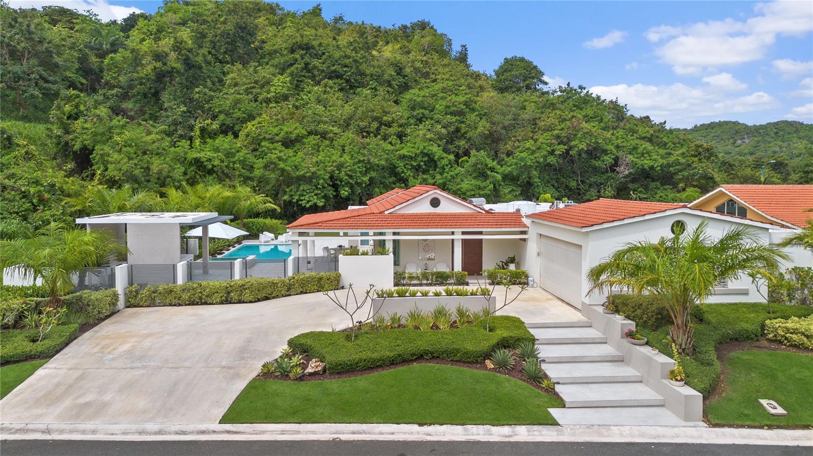 This exceptional single-story residence is situated on a premium corner lot of 1,161 square meters, offering sweeping mountain views and abundant space. With 3,696 sq ft of thoughtfully designed living space, the home features 4 generously sized bedrooms, 4 full bathrooms, and a convenient half bath. The spacious master suite includes a bonus area perfect for a sunlit home office or private gym. Enjoy resort-style living with a private pool, jacuzzi, and a fully equipped covered outdoor kitchen—perfect for hosting and entertaining guests.

The property is in excellent condition and includes a two-car garage with additional storage space, a 40KW generator, a 200-gallon cistern, and a solar water heater for enhanced energy efficiency. This is a rare opportunity to own a well-maintained, luxurious home that offers the perfect blend of comfort, functionality, and room to relax or play—all with stunning views.