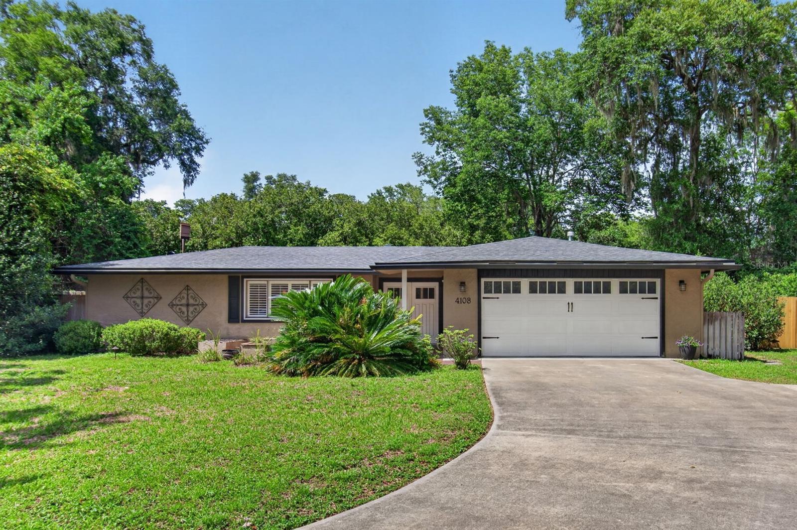 Welcome to Monterey and this 4 bedroom, 2 bath plus Florida room home with over 2,200 square feet in the heart of northwest Gainesville. Settled on the cul-de-sac of a quiet, neighborly street, this home is perfectly suited for anyone looking for a little piece of serenity and community. This fully renovated, 1974 ranch home boasts a spacious open-floor plan with laminate and tile flooring throughout (no carpet), crown molding, high-end finishes, large windows and French doors to enjoy the Florida sun. In the kitchen you’ll find chef-ready Kenmore Pro stainless kitchen appliances, including 6-burner gas range, side-by-side refrigerator/freezer, drawer-style microwave, farmer sink and separate large-capacity under-counter ice maker. There’s also a walk-in pantry with wine cooler.  Additional features include: plantation shutter blinds, granite countertops, soft-close drawers, ample lighting, and ceiling fans in all bedrooms and great room. The spacious owner’s suite has a large open bathroom with walk-in shower, double vanities, private toilet, two walk-in closets and French doors leading to a side patio with outdoor shower. The three remaining bedrooms all have large windows, spacious closets and are conveniently centered around the second bathroom. The kitchen is open to the Florida room and great room with gas fireplace. Outdoors, the property is fully landscaped including permanent garden features, mature trees and shrubs, updated fencing and natural gas patio grill with built-in granite counters. The yard is ideal for gardeners, birders, and those looking for space to run, play and entertain. Plus, there’s room to add a swimming pool. The patio is a birders paradise with visits to the backyard flora and feeders by cardinals, wrens, titmouse, chickadees, down/red-bellied/pileated woodpeckers, waxwings, blue jays, mockingbirds, catbirds, red-winged blackbirds, grackles, bluebirds and warblers, and painted buntings. Swallowtails, hawks, and ospreys are often seen soaring overhead with crows and butterflies cruising below the canopy. Worried about a power-outage? No problem, you’ll be able to watch the Weather Channel in the comfort of your air-conditioned, well-lit home with power supplied by a full-home 22KW Generac generator. Internet service is currently provided by IQ Fiberoptic. Monterey has no HOA and is conveniently located in the heart of Gainesville. Within 3 miles are restaurants, banks, credit unions, doctors, dentists, grocery stores, pet store, library and the Gainesville Community Playhouse.  It’s a short, easy commute to North Florida Regional, VA and UF Health hospitals, Santa Fe College, and the University of Florida! Call today to see this move-in-ready home for yourself!