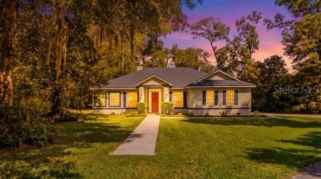 This custom-built Today Homes residence has been exceptionally maintained by its original owner, with years of attentive care evident throughout the home. Set on 2.1 private acres in one of DeLand's most sought-after locations, the home offers a rare balance of privacy and accessibility. Its quiet setting feels worlds away, yet shopping, restaurants, Interstate 4, and historic Downtown DeLand remain just a short drive from home.
Inside, 2,025 square feet of living space features three bedrooms, two bathrooms, and a flexible bonus room tucked behind a sliding barn door that easily serves as a home office, playroom, hobby space, or media room. High ceilings create an open, airy feel, while new luxury vinyl plank flooring throughout the living areas and bedrooms gives the home a fresh, updated look. Surround sound enhances the main living space, while the wood-burning fireplace creates a warm and inviting focal point for relaxing evenings at home.

The kitchen has been updated with all new appliances and opens naturally to the living and dining areas, creating a comfortable space for gathering with family or hosting friends. Just beyond the kitchen, the spacious laundry room is thoughtfully designed with a utility sink, washer and dryer that convey with the home, and direct access to the attached two-car garage for added convenience. The primary bedroom serves as a private retreat, complete with its own entrance to the covered back porch where you can enjoy the peaceful surroundings. The adjoining ensuite bathroom includes a large soaking tub, separate walk-in shower, and a generous walk-in closet. A second full bathroom provides exterior access, a practical feature after working outdoors, gardening, or enjoying the expansive property.

Outside, the improvements continue with a brand-new roof, a newly constructed private driveway, a covered back porch, and exceptional curb appeal. The home sits well off the road, creating a quiet sense of seclusion that's difficult to find. A black wrought iron fenced area provides a secure space for pets, while a designated parking area with asphalt millings and a 50-amp RV hookup offers added convenience for storing and servicing a camper or recreational vehicle. The oversized attic offers impressive storage, and the attached two-car garage adds everyday practicality.

Built with quality and cared for with pride, this property offers the kind of space, privacy, and lasting craftsmanship that makes coming home feel like the best part of the day.