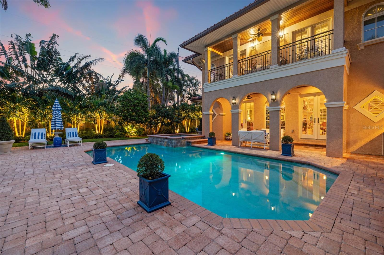 Presenting - 1124 Seville Lane Northeast in St. Petersburg, FL - a stunning home that embodies luxury and elegance. This exquisite residence boasts 5 bedrooms and 4 bathrooms within its expansive 3952 square feet, situated on a lush 11352 square foot lot. Upon entering, you are greeted by a welcoming elegance that leads to a home designed for entertaining. The main level features three bedrooms and two baths, perfect for guests as one is an en suite. The second level hosts two ensuite bedrooms, including the elegant primary suite which is a sanctuary of its own, offering two custom walk in closets, fireplace, built in bar with wine fridge, and a private balcony overlooking the pool. The interior is adorned with impeccable details, including a center dual sided gas fireplace, spectacular built in bar with wine fridge, and kegerator. The kitchen is a chef's delight, and brand new in 2018 with gorgeous granite counters and a slide open window to the outdoor grill. Step outside to discover the oasis of the backyard, complete with an outdoor kitchen, a sparkling pool and spa and a charming patio all surrounded by amazing landscaping with accent lighting. This home is a rare find, seamlessly blending sophistication with comfort, offering an unparalleled living experience. Don't miss the opportunity to make this luxurious retreat your own.