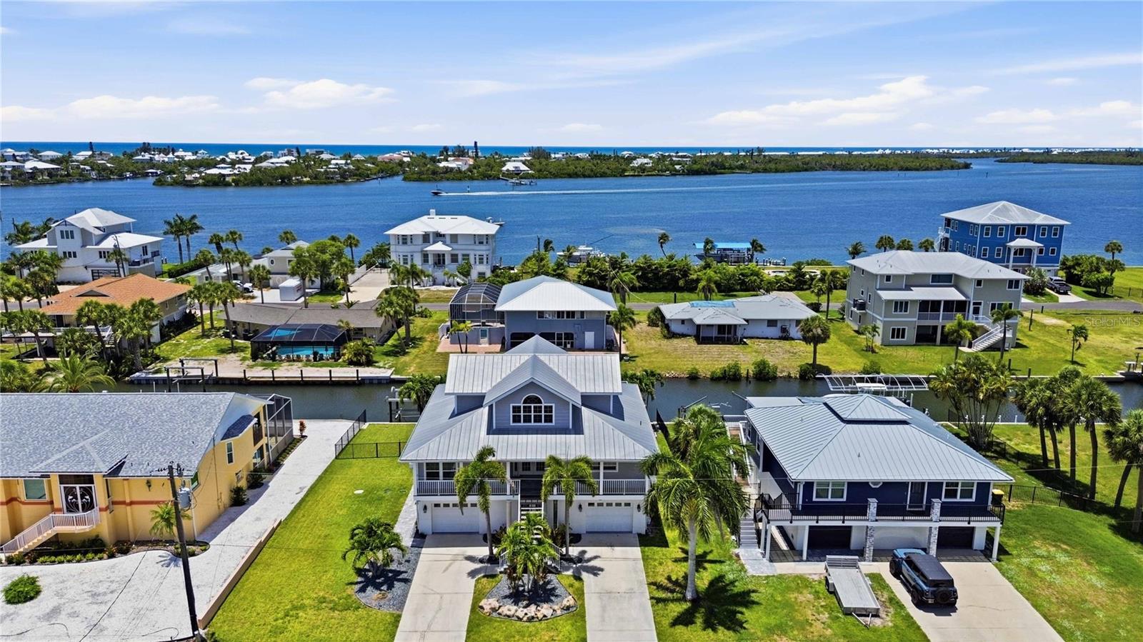 Stunning waterfront living with breathtaking Lemon Bay sunset views with no bridges to the Gulf. This unique 3-story home in the quiet neighborhood of Palm Point delivers the full coastal lifestyle with 90' of saltwater canal frontage, a concrete seawall, and a 40' wood dock complete with a fish cleaning station, water, and electric. Two 7,500 lb boat lifts with brand new motors sit on either end of the waterfront, ready for your fleet.
Step inside through the grand double door entrance where dual staircases merge into one and welcome you into an impressive foyer. The main living level features a spacious great room with soaring views through two large pocket sliding doors that open to a large balcony (12'x48') spanning the width of the home overlooking the water with great views of the bay. The large kitchen boasts new stainless steel appliances including a beautiful range, dishwasher, and refrigerator, plus a peninsula bar with plenty of room for dining and entertaining. Two guest bedrooms are split by a spacious guest bathroom, and an inside utility room with washer and dryer adds everyday convenience.
The third floor is your private retreat with a primary bedroom featuring impact resistant PGT windows and French doors opening to a private balcony (7'x16') with direct Lemon Bay views. The primary bathroom is beautifully tiled with a glass enclosure and connects to a huge walk-in closet.
Outside, the balcony staircase leads down to a resort style pool and spa deck featuring a gunite poured concrete pool installed in 2022, open deck space, and full fencing for privacy. The ground level has a massive bonus room between the two garages has been finished with a half bath and large living space with endless oppurtunties (man cave) with sliding doors out to the pool area, perfect for a bar, media room, or flex space.
Parking is a dream with two garage bays with an epoxy finished flooring. One is double length with room for two vehicles, and the other offers space for an additional car, golf cart, and fishing gear. Two driveways lined with beautiful palm trees and landscaping lead to each side.
Built to last with a concrete slab foundation, block exterior walls with stucco on the first floor, poured concrete second floor, and framed upper floors with vinyl siding. Recent upgrades include: HVAC unit replaced (2023, 2 zone system serviced regularly), hot water heater (2023), septic tank (2023), pool and spa pumps (2024), Rain Bird irrigation system (2022), third floor soffits (2023), and impact resistant PGT windows and French doors in the primary suite. Two zoned HVAC keeps every level comfortable.
This is true Florida waterfront living at its best. Sunsets, boating, fishing, and entertaining all from your own backyard.