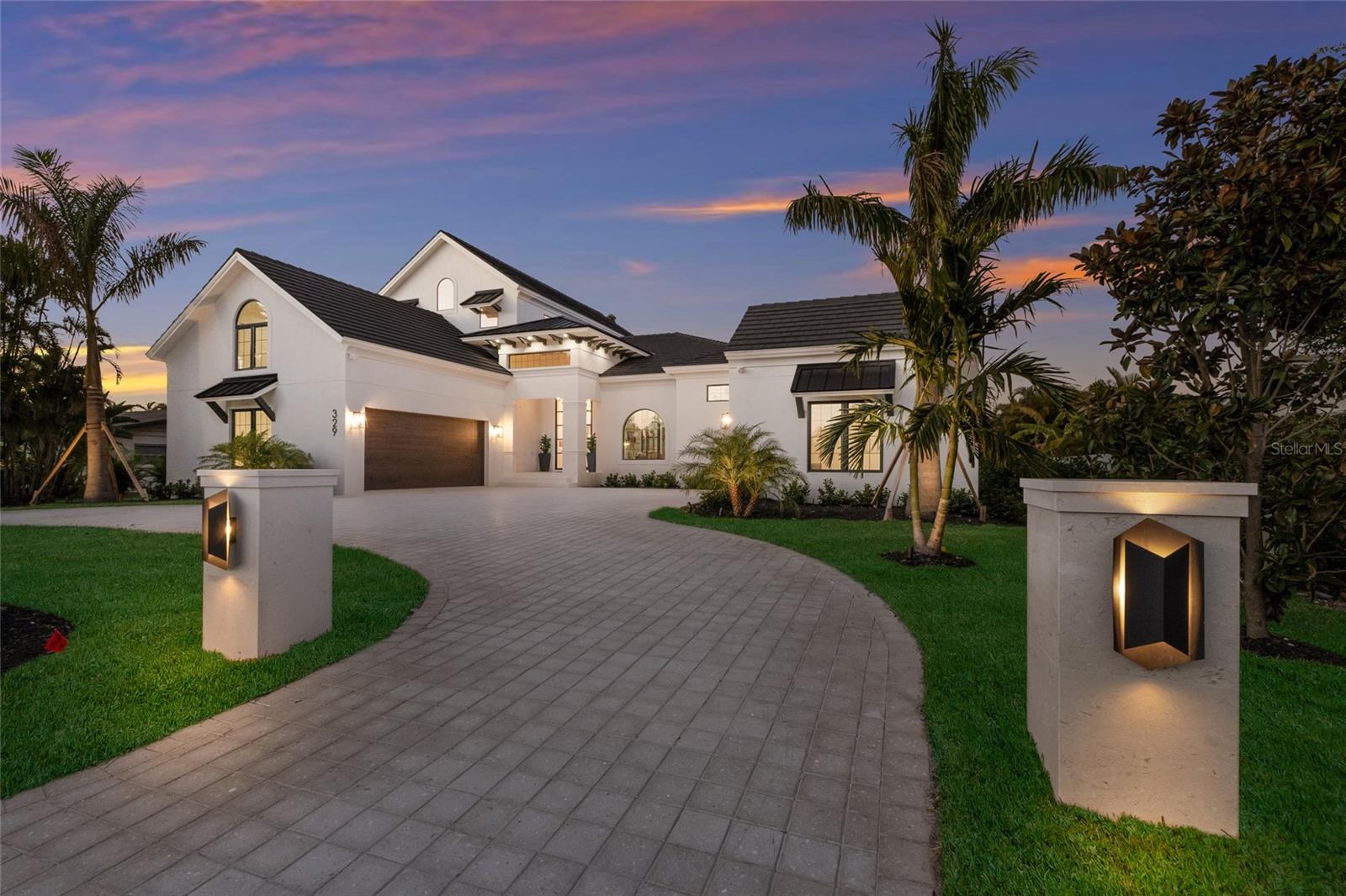 One-Of-A-Kind, New Custom-Built residence on prestigious Bird Key, offering a rare combination of scale, elevation, and thoughtful design. Spanning over 4,900 square feet, this refined contemporary home blends modern architecture with Florida’s timeless coastal charm and is carefully planned to maximize privacy, comfort, and functionality. The home features four bedrooms, four-and-half bathrooms, a private office, and a separate guest suite/casita with its own bedroom and living area. A circular driveway leads to a striking double-height entry with oversized glass doors, opening to dramatic ceilings and light-filled interiors. The elegant great room, anchored by a fireplace, flows seamlessly through walls of glass to the covered poolside terrace with tray ceiling. Designed for both everyday living and entertaining, the gourmet kitchen offers a substantial island, high-end finishes, and a generous butler’s pantry. The dining area opens to both the terrace and a fully equipped summer kitchen. The first-floor owner’s suite is a retreat with direct terrace access and a spa-inspired bathroom. A private two-room casita provides ideal guest accommodations, while two additional en-suite spacious bedrooms are located upstairs. Additional highlights include an elevator servicing four levels, a mezzanine-level bonus room that can be used as a gym or media room, a well-appointed laundry room, and an impressive 33 x 15 ft enclosed pool and spa, creating a substantial extension to the home’s indoor living areas. Elevated 11 feet above sea level and positioned on a larger-than-typical lot, this residence stands apart for its unusually generous homesite, allowing for exceptional first-floor living and expansive outdoor spaces rarely found in new construction on Bird Key. Bird Key offers an exceptional location just minutes from downtown Sarasota, the shops and dining of St. Armands Circle, and the beaches of Lido Beach. The Bird Key Yacht Club is currently undergoing a full rebuild and is anticipated to reopen in 2026 as one of Sarasota’s premier destinations for boating, dining, tennis, and social events. Please note image of the gym (Bonus Room) has been digitally staged.
