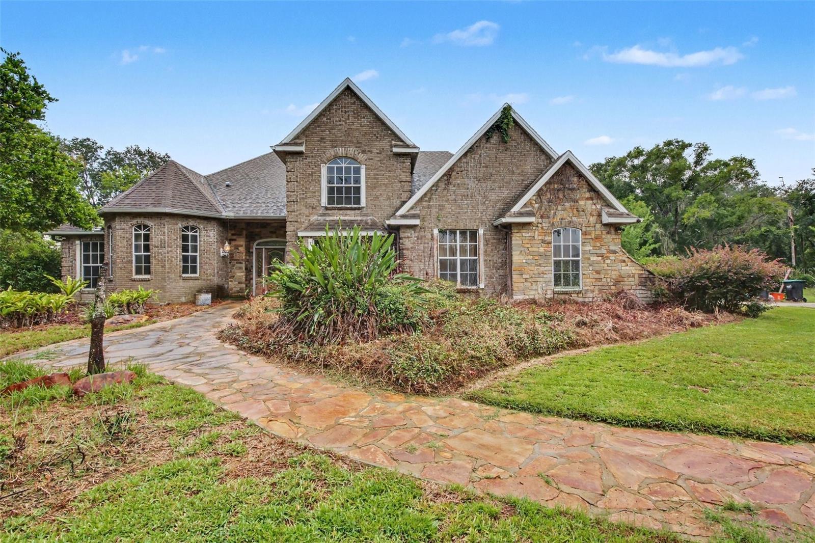 Virtually Staged. Discover this rare custom waterfront oasis offering unparalleled privacy! This 4-bedroom, 2.5-bathroom custom home, built in 1999 in the desirable Cape Orlando Estates subdivision, features 480 feet of direct frontage on Lake Jennifer and sits on a massive lot. Mature landscaping enhances the serene, private estate-like setting.

Boasting 2,875 square feet of living space, the home features a spacious master bedroom and master bathroom conveniently located on the first floor. The large great room impresses with dramatic cathedral ceilings and a cozy fireplace insert. Upstairs, a versatile bonus room at the top of the stairway offers its own private entrance to the screened patio — perfect for entertaining or a private retreat.

Outside, enjoy resort-style living with a custom inground pool complete with grotto waterfall, an outdoor kitchen by the lake front, and expansive screened areas including a deck, patio, and 2nd-floor balcony with beautiful lake views. Additional features include a 2-car garage, central air conditioning, and forced air/electric heating.While the property will benefit from some updates and repairs after purchase, these factors have been carefully considered in the pricing.