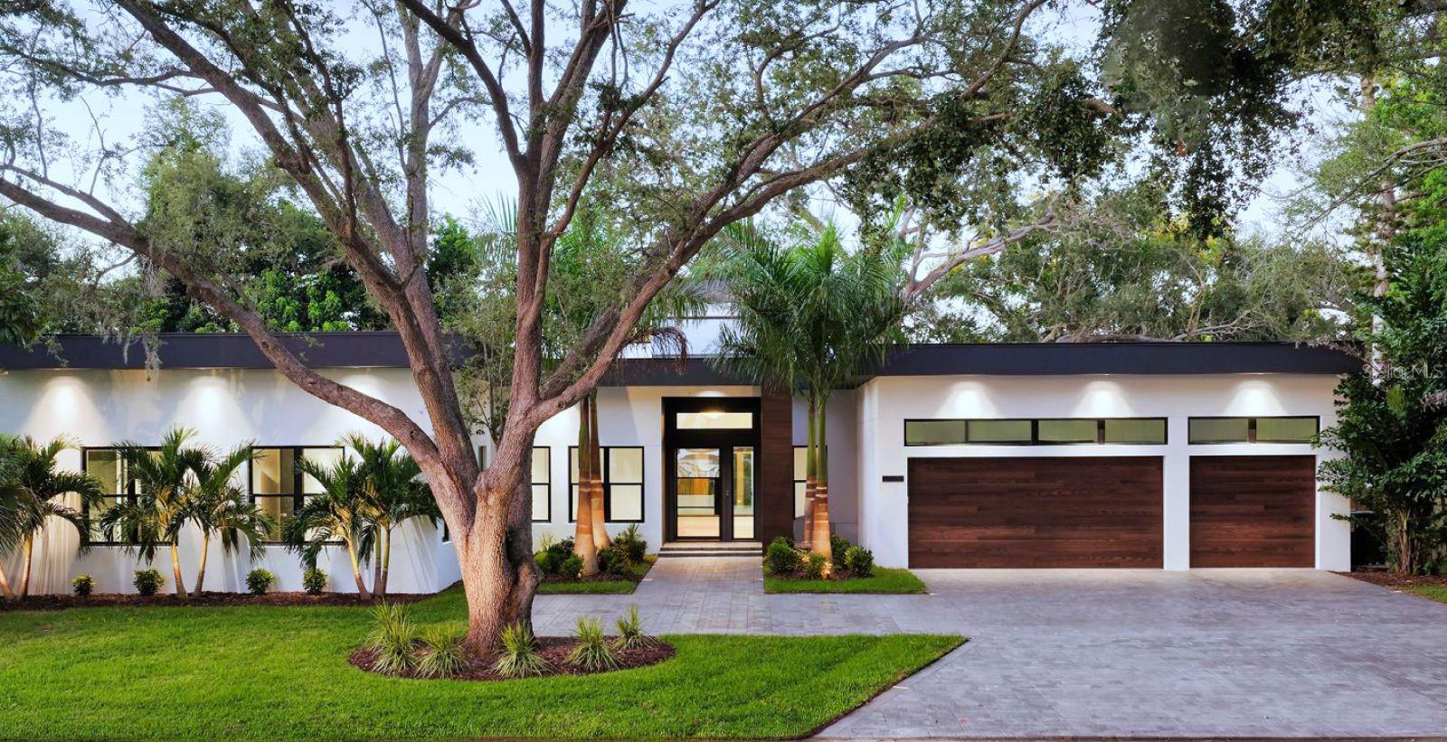 One or more photo(s) has been virtually staged. Experience luxury West-of-Trail living in Sarasota’s coveted Oyster Bay neighborhood. This newly built 2026 custom residence offers 5 bedrooms, 5 full and 2 half baths—all on one thoughtfully designed living level—featuring 4,545 sq. ft. under air and 5,689 sq. ft. total. Set on an impressive 130' x 150' corner lot (0.45 acres), the home is surrounded by a lush tropical oasis that provides exceptional privacy.  A dramatic two-story foyer with 21’ ceilings and a steel-and-impact-glass entry door welcomes you inside. Engineered oak hardwood flooring, 10” baseboards, and sleek horizontal receptacles enhance the home’s modern architectural aesthetic. The expansive open-concept kitchen and great room are flooded with natural light from ten windows and four 20’ hurricane-impact glass sliders that open to the outdoor living space.  The gourmet kitchen is a chef’s dream, offering an 8-seat center island, large walk-in pantry, quartz countertops, and premium appliances including a Bosch 36” natural gas/induction cooktop, 36” Thermador refrigerator column, 24” Thermador freezer column, 24” full-height Thermador wine cooler, Bosch dishwasher, and 30” Bosch oven/microwave combo.  Retreat to the luxurious main suite featuring a Wetstyle tub with wood surround, marble accents, and slate and porcelain flooring. Additional highlights include level-5 smooth interior walls, 8’ solid-core and obscure-glass interior doors, a stunning 175-bottle wine room with marble wall and glass enclosure, Samsung pedestal washer & dryer, and an advanced alarm and exterior security lighting system.  The outdoor living area is designed for year-round enjoyment with a summer kitchen equipped with a Blaze 42” gas grill, sink, and under-counter refrigerator. A 15’ x 28’ pool and spa with a custom waterfall feature, plus an outdoor shower, complete this private retreat. The property also offers an irrigation system and a spacious 3-car garage. An exceptional opportunity to own a brand-new, luxury single-level home in one of Sarasota’s most desirable West-of-Trail communities.