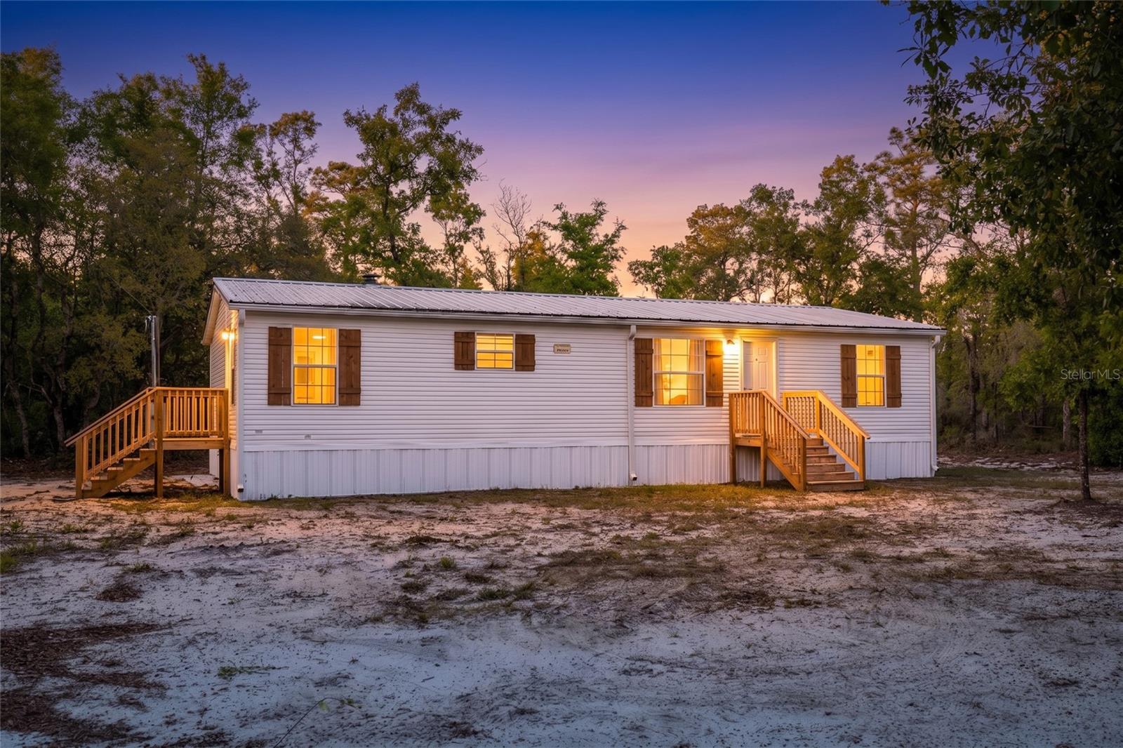 1.25 acres in rural setting, doublewide manufactured home offers privacy, space, and a list of recent upgrades. Enjoy the privacy while still having a move-in-ready home with modern touches throughout. New laminate flooring, updated light fixtures throughout, and new ceiling fans with remote controls, creating a fresh and comfortable living environment. The kitchen and bathrooms have been refreshed with new cabinet hardware and updated faucets, along with new toilets. The spacious primary suite features a walk-in closet and a large en-suite bathroom with a walk-in shower. The secondary bathroom also includes an oversized walk-in shower, offering both style and functionality.
Major system updates provide peace of mind, including a new well (2026), new septic system (2026), water heater (2026) along with a durable metal roof. If you’re looking for a private country retreat with modern upgrades and room to spread out, this property is a must-see! This home is a second set manufactured home; VA financing may be available for qualified buyers.