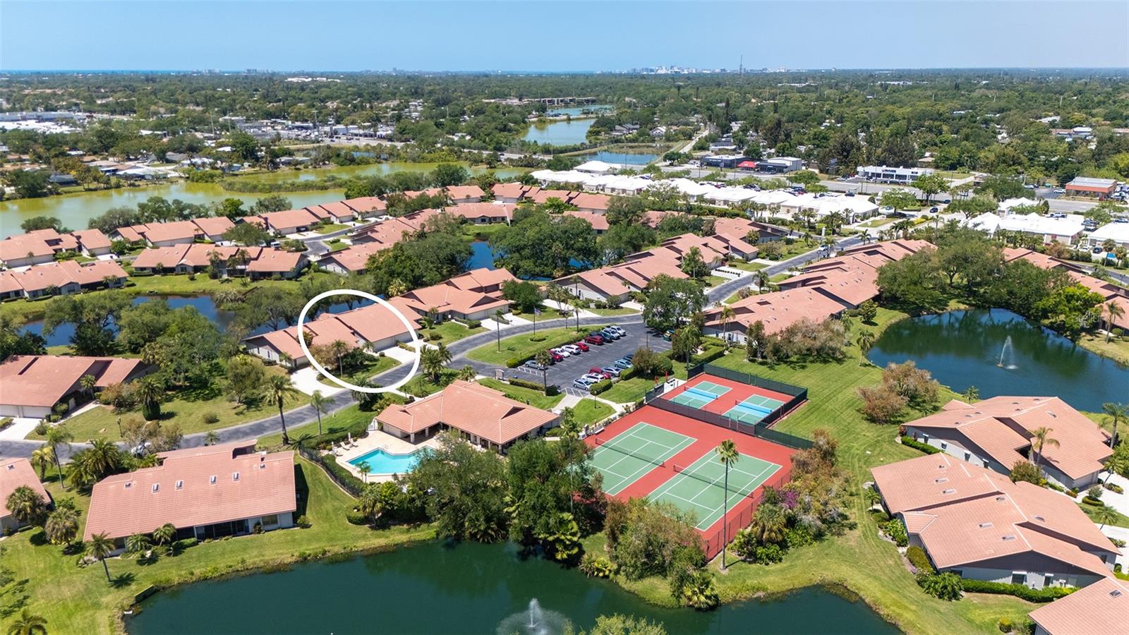MOVE-IN READY and maintenance-free, this beautifully updated lakefront villa offers the perfect blend of modern comfort and serene Florida living in the highly desirable 55+ community of Lakeshore Village! Featuring 2 bedrooms plus a spacious den, 2 baths, and 2,024 sq. ft., this meticulously maintained home showcases wide plank luxury vinyl flooring, soaring vaulted ceilings, and stunning water views throughout. The beautifully updated kitchen is a chef's delight with granite countertops, upgraded cabinetry, stainless steel appliances, and a dry bar with additional storage in the breakfast area, perfect for casual dining or entertaining. The spacious living room flows seamlessly into the enclosed lanai, creating additional living space and showcasing breathtaking lake views and peaceful wildlife right outside your door. Electronic hurricane shutters at the sliding doors provide added peace of mind. The private primary suite features crown molding, lake views, a large walk-in closet, and a beautifully updated ensuite bath with dual quartz-topped vanities and a large tiled walk-in shower. On the opposite side of the home, the guest bedroom sits adjacent to a fully updated bath, while the oversized den with pocket doors offers the flexibility of a home office, hobby room, or potential third bedroom. Additional highlights include a large laundry room, a spacious 2-car garage with extra storage and hurricane-rated garage door, new A/C and ductwork (2021), advanced air sterilization system (2024), whole-home re-pipe (2023), upgraded electrical panel with surge protector, and newer dishwasher (2021). Lakeshore Village offers resort-style amenities including a heated saltwater pool, clubhouse, tennis, pickleball, billiards, library, fishing lakes, and an active social calendar. Conveniently located near shopping, dining, golf, medical facilities, and just minutes to world-famous Siesta Key Beach, this is Florida living at its finest!