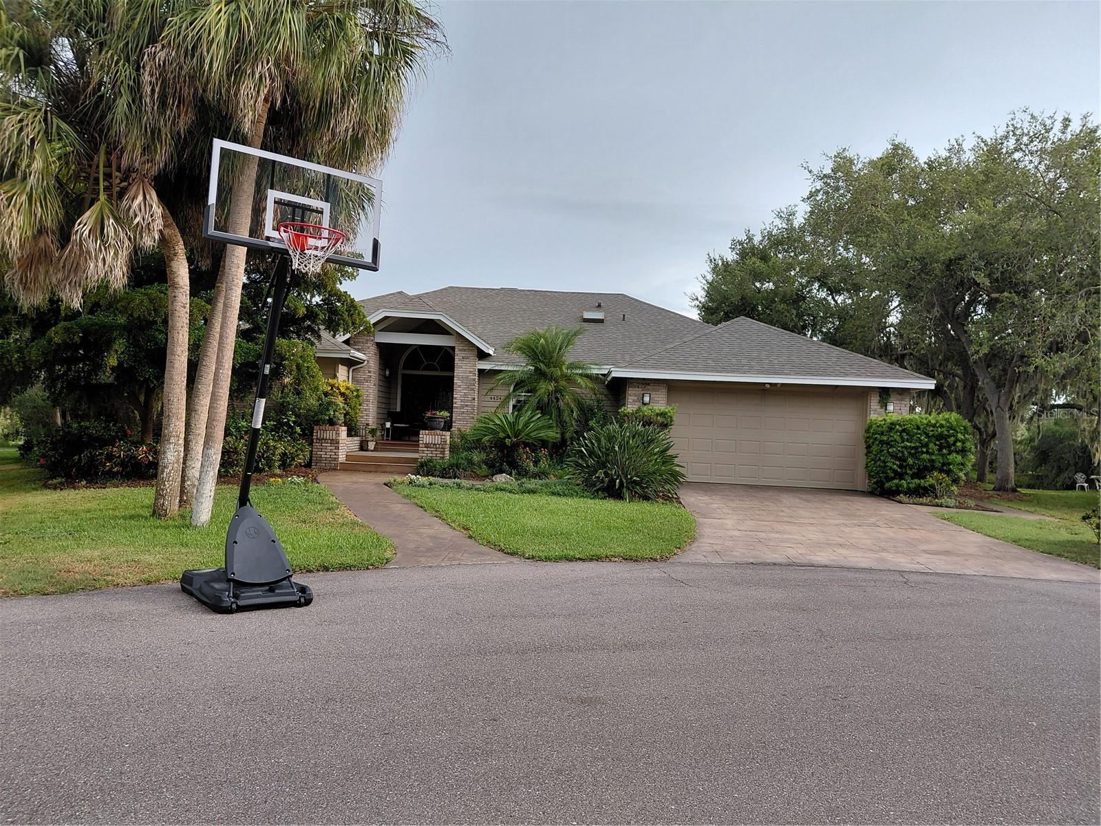 Welcome to this charming custom home located at the end of a cul-de-sac in one of Sarasota’s most desirable (and very friendly) neighborhoods with enchanted Spanish moss covered oak tree canopies. Gorgeous gardens with flowers surround the house. Enjoy stunning lake views and partial ownership of a private island of palms—your slice of paradise! Inside, the home has custom textured and raised ceilings with lovely cut outs, slopes and curves instead of squared rooms. This home offers a flexible layout with separate living, dining, and family rooms. The kitchen features granite countertops, wood cabinetry, a large pantry, a separate beverage/desk area, and a sunny breakfast room all with views of the pool and lake. A spacious master suite has a walk-in closet with shelving and a luxurious bath, complete with a large soaking tub, walk-in shower with double showerheads and sliding door leading out to a private deck and hot tub/pool area. The second and third bedrooms each have cozy lofts with ladders, while the fourth bedroom has a walk in closet and is ideal for guests or a home office, with a bathroom access door. An oversized utility room provides storage and additional space for work or hobbies. Step outside to a true retreat with a resurfaced pool and travertine deck and outdoor kitchen all with views of the lake and island. Lots of wildlife to observe with birds, ducks, turtles and more. A screened in lanai has both shaded and open areas, perfect for entertaining or relaxing in the pool with a brand new heat pump, pool cover, pool pump and solar ionizer to keep pool clear. This lovely home checks all the boxes and is a must see to appreciate the beauty!