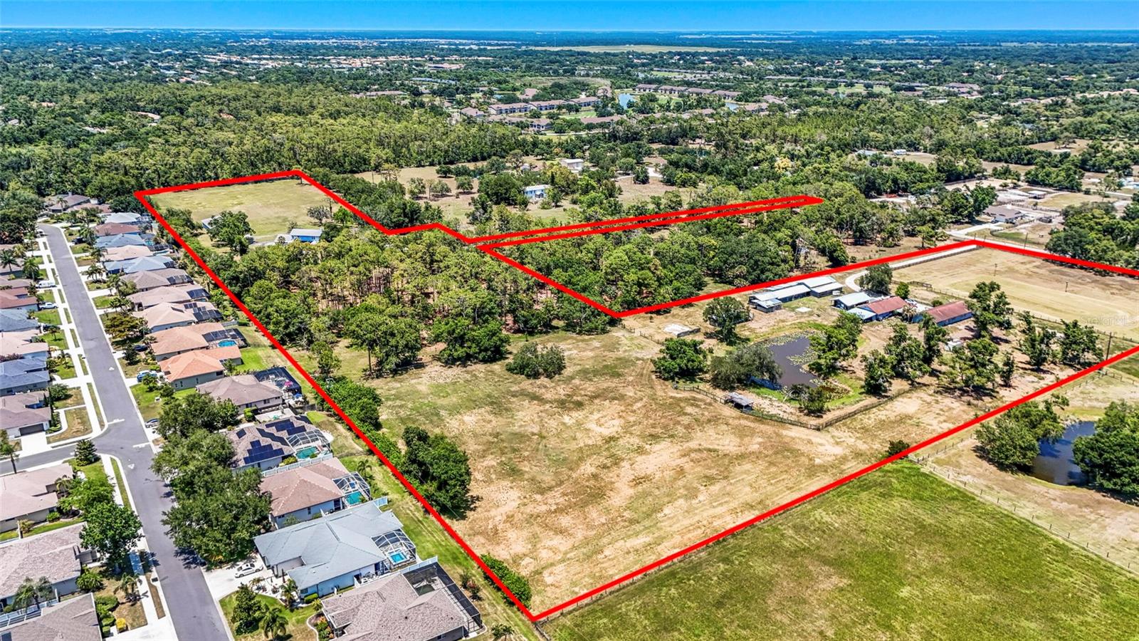 Rare opportunity to acquire an approximately 18.28-acre assemblage consisting of three contiguous parcels in one of Sarasota's most desirable locations. This is a true needle-in-a-haystack opportunity for a private equestrian estate, multi-generational family compound, hobby farm, long-term investment, or legacy property, all right in the heart of Sarasota.

The assemblage includes three concrete block residences totaling approximately 5,592 square feet of living area, 10 garage spaces, a pool, approximately 22 horse stalls, five paddocks/pastures, multiple barns and utility/outbuildings, including a 4,000 square foot concrete block barn with attached four-car garage, two ponds, extensive fencing, and significant existing equestrian infrastructure.

The residences require renovation, updating, or restoration, creating an exceptional opportunity to reimagine and transform this unique property into a premier estate or trophy compound.

The entire property is located in Flood Zone X, and OUE zoning provides exceptional flexibility and the potential for multiple legal homesites. The property is currently serviced by well and septic; however, public water and sewer are available on site for future connection, which is exceptionally rare for acreage properties of this size. Recent land clearing and site improvements have been completed.

Properties of this size, configuration, and location are nearly impossible to find in today's market. Seller's preference is to sell the assemblage as a single offering, although alternative proposals may be considered.