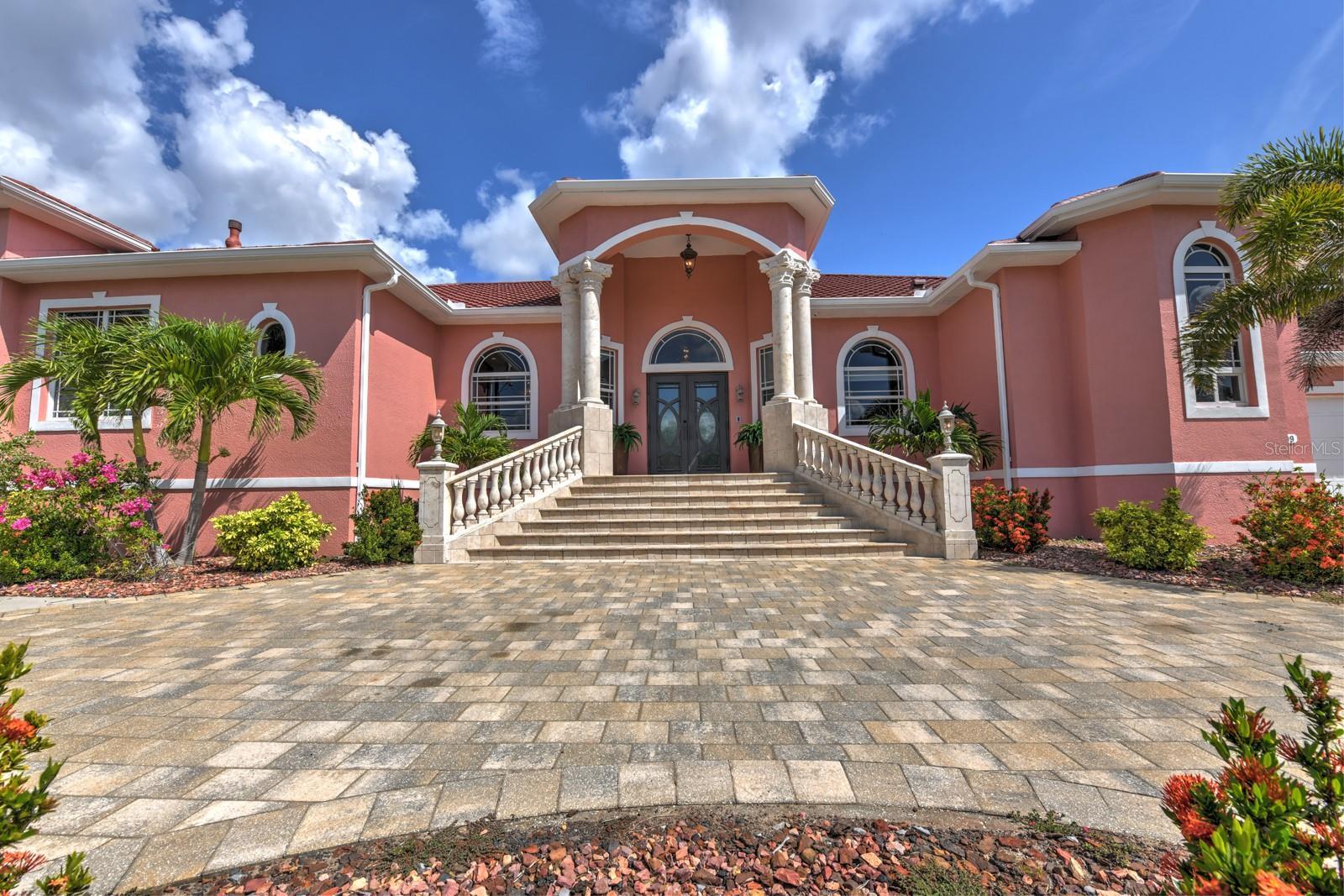A BOATERS DREAM HOME!! 5 MINUTES TO OPEN WATER, 60 MINUTES TO THE I.C.W. and the GULF OF AMERICA! Despite it location on an excellent canal, THIS HOUSE HAS NO HISTORY OF FLOODING!! Breathtaking water views from your massive screened LANAI with 1961 square feet of saltwater POOL and outdoor space, and featuring a Gazebo-like custom outdoor kitchen and entertaining area. The HUGE DOCK sports 2 boat lifts, one covered, and 2 floating jet ski ports with water and electricity. Step inside this grand, custom-built residence to be greeted by a large GREAT ROOM with soaring 12 foot ceilings with an abundance of natural light and awesome water views. High-end finishes abound, from the exquisite tile and travertine flooring to the natural stone countertops. The CUSTOM KITCHEN is a chef's delight featuring all-new cabinetry and excellent WOLF appliances. The Master Bedroom and Bath are a beautiful private oasis sure to delight the most discriminating taste. There is a handsome private OFFICE, and a custom MEDIA ROOM with wet bar and surround sound theatre. The huge garage has space for 4 vehicles, or 2 vehicles plus toys or a workshop. The new 2023 METAL ROOF and the newer impact windows far exceed Florida's hurricane standards. Two newer HVAC systems (2021 and 2022), two tankless water heaters (2020 and 2023) and a 500-gallon underground propane tank ensure maximum comfort and dependability. Other improvements include a heated salt water pool, water softener and reverse osmosis water system, and large boat canopy. The excellent Chrlotte Harbor Yacht Club is across the street with a marina, fuel, a nice restaurant and bar open to the public, and many fun activities for members. A few minutes away by CAR OR BOAT are outstanding restaurants and pubs, the wonderful Fisherman's Village, the incredible Sunseeker Resort, 3 marinas, public golf courses, and numerous festivals and musical activities. If you seek the ultimate in luxury, convenience, and the unparalleled MAGIC of coastal Southwest Florida, you have arrived!!