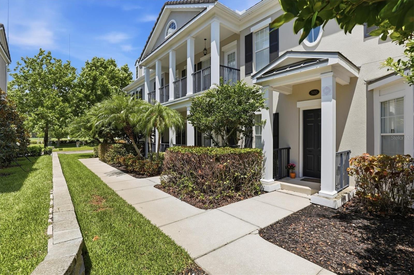 Nestled within the prestigious Echelon City Center at Carillon Park, this immaculate, maintenance-free townhome offers 3,660 sq ft of refined living with the flow and presence of a single-family residence. Enter beneath soaring coffered ceilings to an open, light-filled floorplan anchored by a fireplace and grand living and dining rooms ideal for entertaining family and friends. The chef’s kitchen features a generous island, two-tone wood cabinetry and newer stainless appliances, while wood-look ceramic tile spans the entire first level, including the butler’s pantry and Primary Suite. The sumptuous Primary Suite features two expansive walk-in closets and a spa-like bath with upgraded countertop, soaking tub and glass-enclosed shower. French doors open to a private courtyard for serene outdoor living. An elegant staircase ascends to a large family-room loft, a Junior en-suite, an additional bedroom, full bathroom and a French Door Juliette balcony.  Rear stairs from the garage access a 500-sf studio with kitchenette, full bath and closets—perfect for multi-generational living. Thoughtful recent investments include 34 impact-rated SoftLite windows and French doors (2023), new flat roof (2023), HVAC (2021), and water heater (2025). The oversized two-car garage features a premium floor coating and whole-house water conditioner. Residents enjoy a luxury pool, clubhouse with kitchen, fitness center, miles of trails and lakeside boardwalk, plus proximity to Topgolf, shopping, dining, I-275, Tampa, St. Pete, the Gulf beaches and two international airports. HOA fees of $565 cover exterior maintenance.
