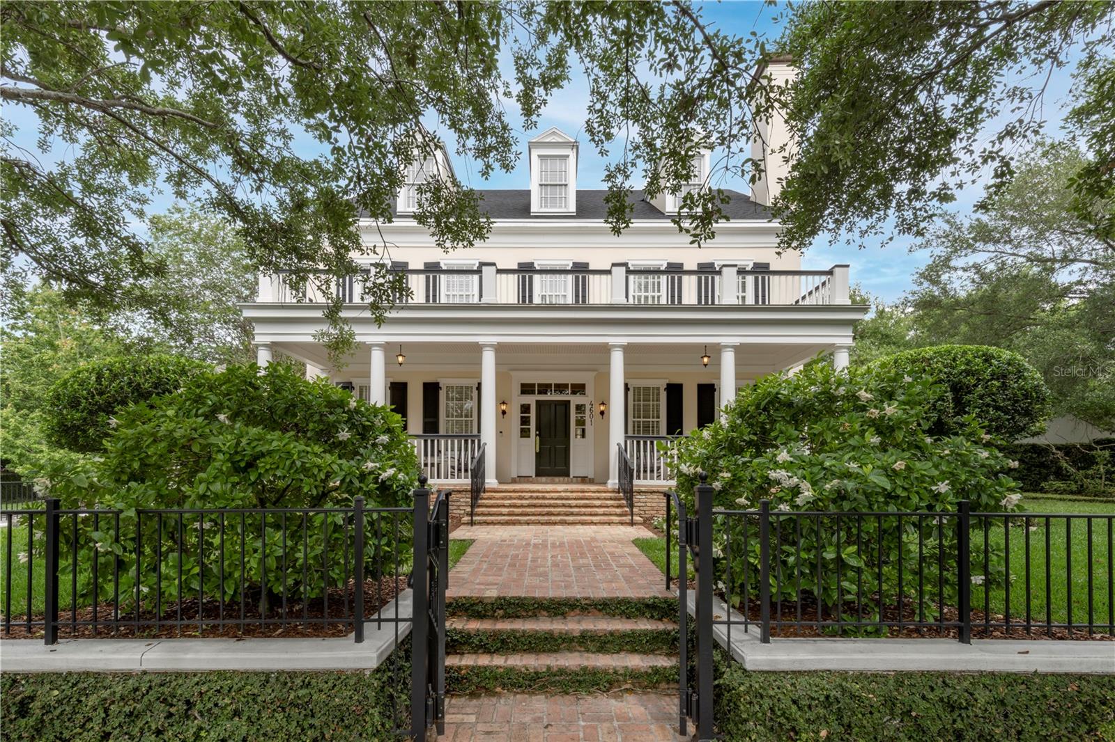 Perfectly nestled in Baldwin Park on the flagship street, this one-owner stately Georgian-style home exudes elegance inside and out. This is truly a wonderful classic and stately home that was custom built by Derek Builders, in collaboration with LRK Designs, and considered to be resting on arguably the best lot in all of Baldwin Park, at the high-profile corner of New Broad and Hopper, with over 250 feet of frontage. The owner and developer had first lot selection to thoughtfully select this specific property being the developer of Baldwin Park. While the iconic New Broad Street Park is out front of the property, quiet Virginia Park is nearby out the back of the property. A charming brick pathway leads to the front entry, enhanced by a stunning portico that lines the façade while comfortably and artfully designed on this oversized lot. Inside awaits a warm and welcoming interior, delicately adorned with hardwood flooring and crown molding throughout. This entire property is designed with incredible indoor and outdoor amenities to welcome your recreational and entertainment pursuits. The backyard invites you to a tranquil retreat, complete with an outdoor kitchen and an enchanting pool with fountain, enveloped by gorgeous greenery and lush landscape. There is a new roof and exterior paint in 2022.  Although extremely well maintained, all interior finishes to include flooring, lighting, hardware, kitchen & all baths are original 2003 construction age.  There is ample on-street parking to augment the oversized three-car garage. With proximity to all the eclectic dining, shopping and entertainment Baldwin Park and adjacent downtown Orlando and Winter Park areas have to offer...