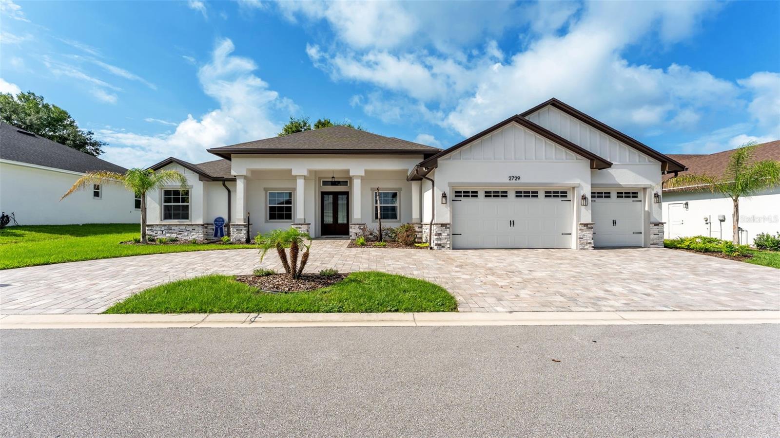 Welcome to this modern farmhouse style BRAND NEW BUILT HOME, located 0.8 mi. from VALLEYVIEW Elementary School & 1.2 mi. from GJHS.  A BOUTIQUE gated community features JUST 12 residences.  The entrance of this north-facing home reveals a sophisticated open layout, where rustic timber beams and 12' high ceilings meet the clean lines of OVERSIZED porcelain tiling.  A true chef’s dream kitchen features quartz counter tops, shaker style wood SOFT-CLOSE custom cabinets, stainless steel appliances, large island with FEATURED CEILING above and a functional walk-in pantry.  The kitchen flows seamlessly into the Great Room, creating an ideal setting for many fun gatherings and effortless entertaining.  The Great Room’s focal point is a custom-designed feature wall adorned with SHIPLAP WOOD PLANKS and a sleek, recessed electric FIREPLACE.  Designed for ultimate privacy, the SPLIT floor plan leads to a primary retreat featuring a spa-like ensuite with a double vanity, a standalone soaking tub, an EXPANSIVE WALK-IN SHOWER, and generous closet space with California Style Shelving.
Designed for seamless outdoor living, the large under-truss lanai offers a shaded retreat with an INSULATED roof and is PREPPED FOR a custom outdoor kitchen. The property also boasts a massive paver driveway and a spacious 3 car garage featuring upgraded insulation in both the roof and ceiling.  Thoughtfully upgraded for comfort and efficiency, this home features LVP flooring in all bedrooms and 8' INTERIOR DOORS THROUGHOUT. The structure is BUILT TO HIGHER STANDARD with a 5/8-inch plywood roof deck, upgraded HIGH-SERIES windows, and SOUND-INSULATED interior walls. Modern conveniences abound, including dual A/C systems, two EV charging outlets, and smart wall-mounted garage openers, while the entire home is pre-wired for seamless TV and internet connectivity.  Beautiful Stone on Exterior.  Leave the car behind! This home is ideally located less than a ten-minute WALK from TOP RATED George Jenkins High and Valley View Elementary. With shopping and amenities only moments away, the location is truly UNBEATABLE.