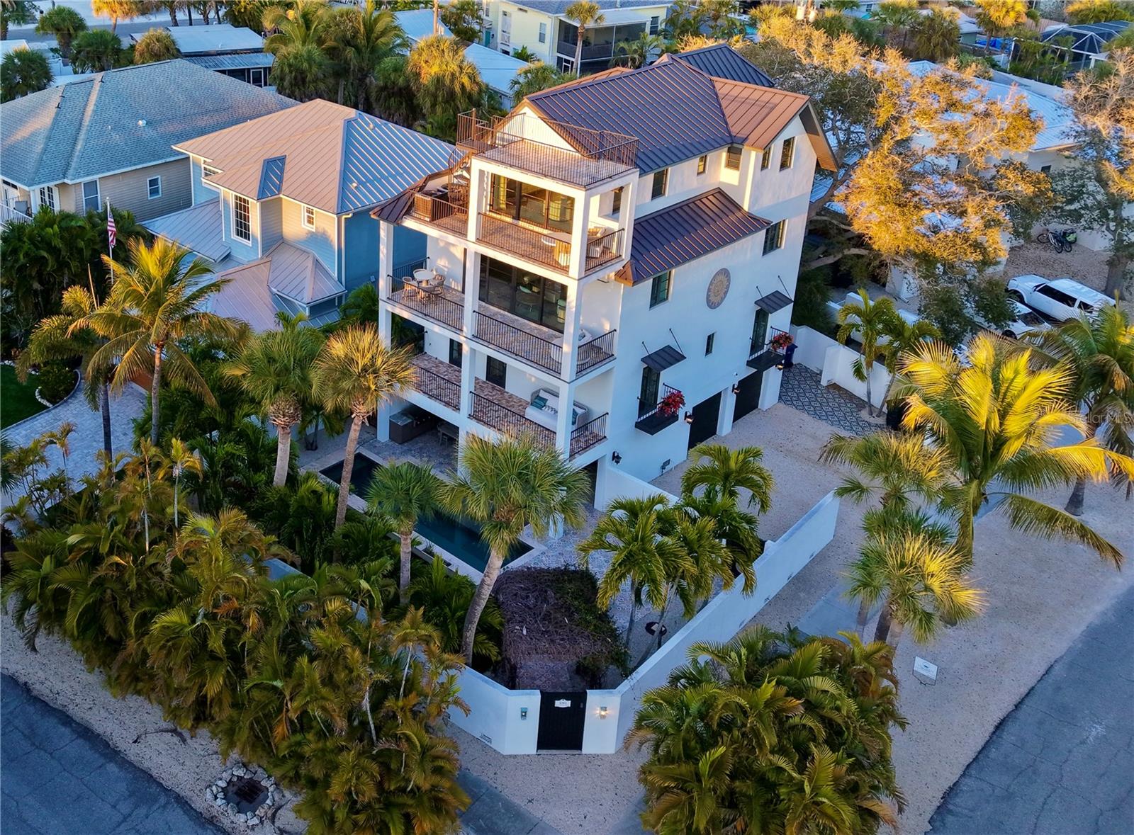 Welcome to a residence where inspired design meets the effortless elegance of Island living. Tucked away on the tranquil side of the Siesta Key Village, this extraordinary home places you at the heart of it all while having it all. With World-renowned beaches and the charming village just steps away… you truly can not beat the location. This 4 bedroom, 3100 sq.ft. home boasts a private boat dock, tropical backyard oasis and terraces with sunset views that never fail to inspire. 

The primary construction of this home was completed in 2018, with a full designer remodel in 2025. This home offers the confidence of modern construction throughout. Levels one through three are concrete block, with a two-by-six wood-frame fourth level and all exterior glass is hurricane impact rated. The home also boasts a standing-seam metal roof, a six-foot privacy wall with keypad-secured metal entry gates. A three-stop elevator services every floor, alongside a striking free-floating steel staircase framed by floor-to-ceiling glass, maintaining open sight-lines across the living spaces. Private bedrooms with en-suite bathrooms are thoughtfully positioned on levels two and four. Each floor opens to a generous covered balcony. Crowning the home is its most captivating feature: a spiral staircase leading from the fourth-floor balcony to a rooftop terrace with sweeping views of Siesta Village, Siesta Beach, Downtown Sarasota, and front-row vantage point to nightly stunning sunsets over the ocean. 

A comprehensive renovation brings a fresh, sophisticated vision to this home. The updates include new luxury hardwood flooring throughout, designer kitchen complete with dry-bar and a luxurious primary bathroom update.  The second level serves as the home’s central gathering space, featuring an open-concept living room, dining area, and kitchen designed for both entertaining and everyday luxury. The kitchen has been elevated with brand-new custom floor to ceiling cabinetry complete with specialty lighting, premium Cambria countertops, as well as new appliances.  The space is complimented by a beautifully designed dry bar and pantry for a refined, luxury finish.The high end finishes are complimented by designer furnishings and decor that convey with the sale of the home. 

At ground level, a two-car garage is complemented by a substantial 440-square-foot covered lanai overlooking a refreshing heated outdoor pool.  The addition of an outdoor kitchen and upgraded, easily maintained, turf and stone landscape create seamless indoor-outdoor living and entertainment. Privacy is not an issue as this home boasts lush landscape and an impressive block  wall enclosed yard.  With Siesta’s gorgeous white sand beaches just a short walk from the home and a private boat dock just across the street enjoying the Ocean is a breeze from this property. The boat dock includes a 10,000-pound lift and space for a second lift, allowing for effortless access to the ocean via a canal.

Siesta Key Village is a cherished walkable community rich with dining, boutiques, and local small businesses, including a Market, that evoke feelings of nostalgia. Yet the greatest luxury remains the timeless evening sunset strolls on the soft white sandy beaches. The Island’s effortless serenity reaffirms why Siesta Key is not merely a destination, but an exceptional place to call home.