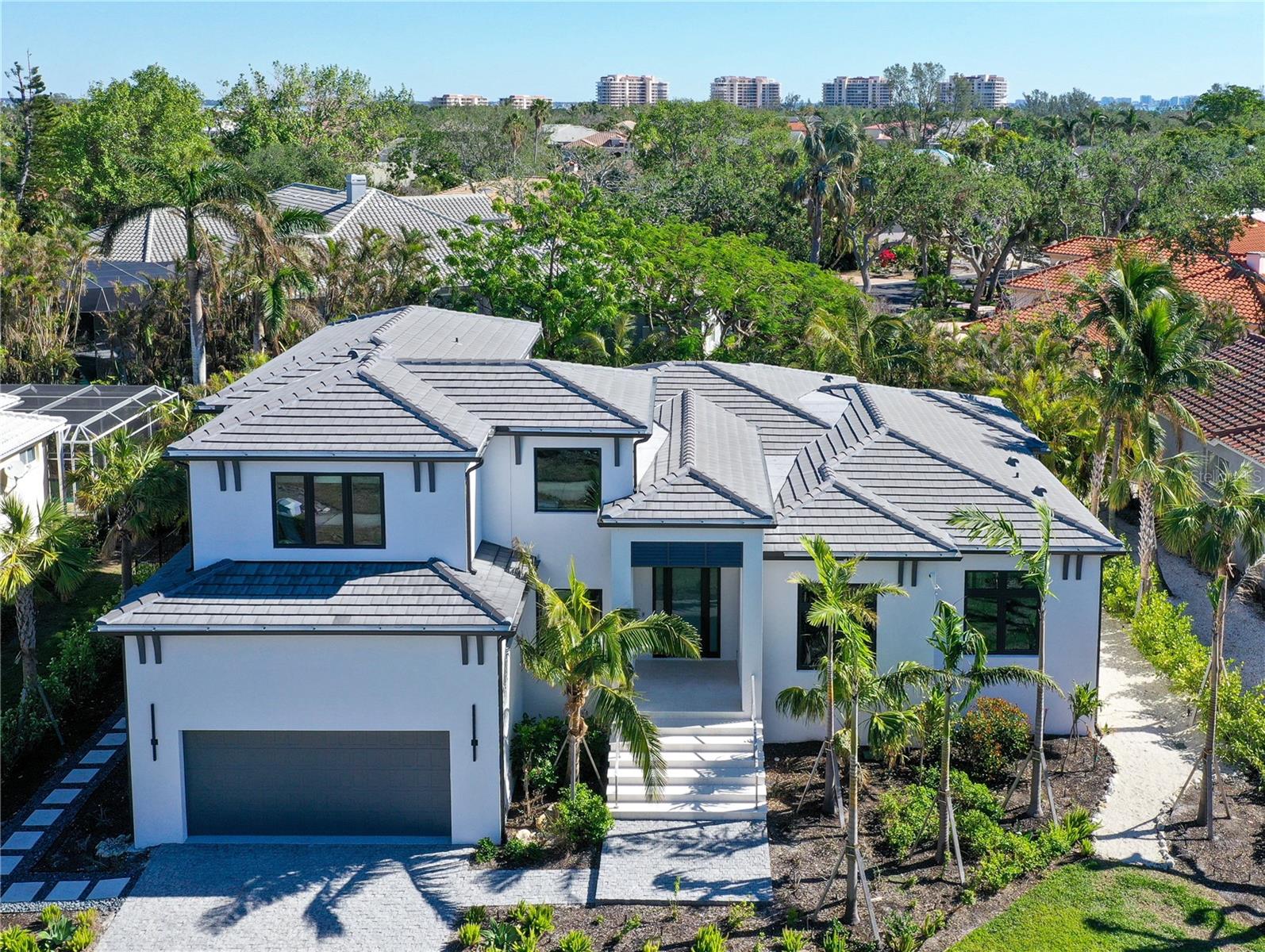 Step into a world of unparalleled luxury and coastal elegance with this brand new coastal contemporary masterpiece in the exclusive double gated and secure Bay Isles community of Bayou Sound.  Designed with impeccable attention to detail, this home offers a seamless blend of sophistication and comfort. The custom chef’s kitchen is a true showstopper, featuring bespoke cabinetry, top-of-the-line stainless steel appliances, an oversized island, and a sunlit dining area with an unobstructed view of the spectacular back yard. The great room is a stunning space designed for both relaxation and entertaining adorned with exquisite built-ins and exposed wood beams offering an inviting atmosphere.  The primary suite is a sanctuary of indulgence, offering a spacious walk-in closet, a spa inspired full bathroom with heated floors, double vanities, and steam shower. The open-concept floor plan enhances the home’s airy and modern feel. A first-floor guest suite, with its' own walk-in closet and poolside bath, ensures privacy and comfort for visitors. Additional first-floor amenities include a refined office, a dedicated yoga/gym area, and a well-appointed laundry room. Upstairs, three generously sized bedrooms and two elegant bathrooms provide plenty of space for family and guests.  The smooth transition from interior to exterior flows effortlessly from the covered lanai and leads you to an exceptional additional 1000 square feet of outdoor living space. The professionally designed landscaping enhances the property's natural beauty, with lush greenery, and special plantings that create a private backyard oasis complete with thoughtfully placed lighting.  The enviable pool and spa provide year-round enjoyment with a soothing ambiance.  The maintenance free oversized two car garage has epoxy floors.  House comes complete with Sonos system as well.  
Perfectly located in South Longboat Key, this home is steps away from the Longboat Key Country Club, where world-class golf, dining, a marina, tennis, pickleball, and boutique shopping await. From here you can also walk to Publix, public tennis center, banking, town hall, post office, library, and Caron Family Pavilion where you can enjoy some local festivities and art shows. Bay Isles residents have exclusive access to Bay Isles Beach Club which has a glorious sandy private beach, picnic area, restrooms and private parking. Drive or ride your bike to the renowned St. Armands Circle, vibrant Downtown Sarasota, and Sarasota International Airport. This rare offering is more than a home; it’s an invitation to live your best life. Schedule your private tour today to experience the countless bespoke details and luxurious touches that set this property apart.