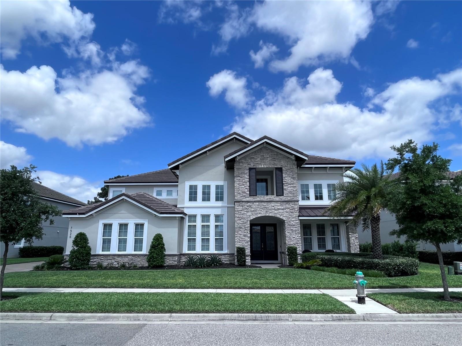 Nestled along the pristine shores of Lake Hancock in the exclusive Overlook at Hamlin community, this luxurious lakefront estate is the pinnacle of waterfront living. Boasting an array of upscale features, this impeccable residence offers an unparalleled lifestyle for those who appreciate the finer things in life. As you step through the grand entrance, you are greeted by soaring ceilings, a private office, wine cellar and sweeping views of the picturesque lake. The gourmet kitchen is a culinary masterpiece, equipped with top-of-the-line Monogram appliances, a spacious pantry, farmhouse sink and expansive island. The living spaces seamlessly flow into the outdoor oasis, featuring a resort-style salt pool, oversized spa, and a sprawling lanai perfect for al fresco dining and entertaining. With a thoughtfully designed indoor doghouse, two luxurious master suites, a screened upstairs balcony with breathtaking lake views, a state-of-the-art theater, and a game room, this residence offers every amenity for relaxation and entertainment. The meticulously maintained grounds are adorned with landscape lighting and a mosquito misting system, creating an enchanting ambiance for evening gatherings. This home exudes sophistication and elegance, offering a rare opportunity to experience the ultimate lakeside lifestyle in the Overlook at Hamlin community.