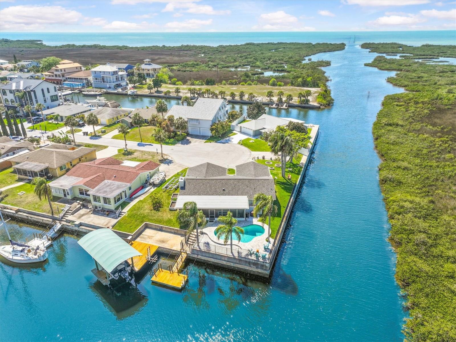 VERY RARE FIND.. NO Steps Here! And NO Flooding in this Beautiful Updated Ground-level Waterfront POOL Home with the Boating Lifestyle Homeowners Dream about. Only Minutes to the OPEN Gulf with 215 ft of Water Frontage. Tucked away on a quiet cul-de-sac, this property offers the Rare Combination so many Buyers are searching for-Ground-level Convenience, a Home that has Not flooded, Tasteful Updates throughout, and a setup designed for Serious Enjoyment on the Water. Outside, the (2017) Wrought Iron Fenced Backyard is made for Relaxing and Entertaining with a POOL (Resurfaced & Salt Water System added in 2018), plus a New (2024) Variable Pool Pump, a Polaris hose-less Pool Vacuum, Adorned by Palm Trees & Attractive Paver Decking (2018), a Floating Dock (2021) for easy Loading and Unloading, a 250 lb Kayak Lift, and a (2018) Fixed Dock with a Covered 10,000-Pound (2018) Boat Lift.  Boat Lift Cover was added (2021) as it is an Important Feature that helps protect your boat from the harsh Florida sun. From your Waterfront Backyard, you can be out to the open Gulf in a couple minutes, making this an Exceptional Fit for Boaters, Fishermen, and anyone who wants Fast, Easy access to the Gulf. The Home also enjoys added Privacy with Preserve Views across the canal. Inside, the Home has a Warm, Inviting Feel with Natural Light, Beautiful Water & Preserve VIEWS, and Updates that make it feel Comfortable & Move-in ready. The Living Area is accented by a Charming Stone Wood-Burning Fireplace with a New (2021) Mantel and Open Vaulted Beamed Ceiling, while the Kitchen has Wood Cabinets (Pot Drawers, Lazy Susan, Cookie Sheet Cabinet), Granite Counters, Island/Breakfast Bar & has been Refreshed with Stainless Steel (2021) Appliances, Updated Backsplash and canned LED lighting and provides an Open Flow into the Dining & Living Spaces that is perfect for everyday living or entertaining guests. Love that the Flooring has all been replaced in 2020 with LV Plank Flooring. The Primary Suite offers a Peaceful Waterfront Retreat with Scenic Views, a Walk-in Closet with Built-in organization, and an Updated Bathroom with New Cabinetry, Dual Sinks & Beautiful Walk in Shower with Glass Shower Door. The additional two Bedrooms are Separate for Privacy. The Guest Bathroom has also been Remodeled with a Walk-in Shower & Updated Vanity. Although not added to the Living Area, the Florida Room which measures 37x12 adds indoor/outdoor living. This Waterfront Home shines not only for its Setting, but also for the many Meaningful Improvements already completed for the Next Owner. Updates include (2018) PGT Storm-Rated Windows and Sliding Glass Doors, New (2021) Interior Doors and Trim, (2021) Double Door Entry Front Doors, Newer (2020) HVAC, (2017) Water Heater, Reverse Osmosis Drinking Water System, a (2017) rebuilt Irrigation System with RainBird Timer, (2021) Insulated Garage Door & (2024) New Driveway, (2021) Epoxy Garage Flooring with a transferrable life-time limited warranty, (2017) Ceiling Fans, updated lighting, and both the Main Roof with 50 Year Owens Corning Duration & Flat Roof replaced in 2024, with the Flat Roof offering a 10-year warranty. Flood insurance is also a plus with assumable primary residence coverage at just 3,345/ year. With a POOL, Covered Boat Lift, Cul-de-Sac Location, Direct Quick Gulf Access, Privacy across the canal, & a home that offers both Peace of Mind and Coastal Style, this is a Rare Waterfront Opportunity that truly checks the boxes