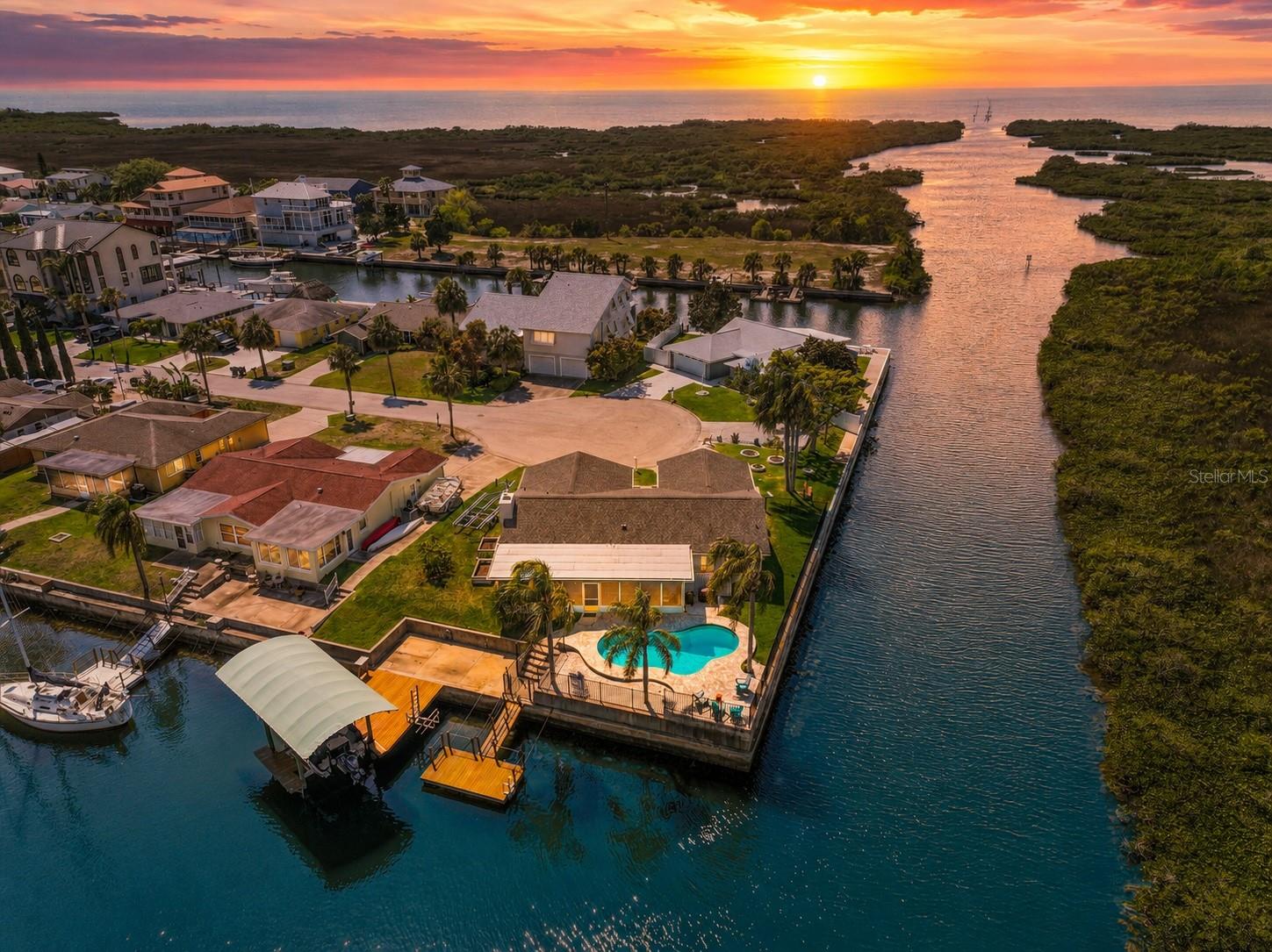 SOME WATERFRONT HOMES ARE BEAUTIFUL… BUT THIS ONE ALSO OFFERS THE PEACE OF MIND BUYERS ARE LOOKING FOR! Sitting high with an elevation of 9.4 ft, this Updated Ground-Level Waterfront POOL Home offers a combination that is becoming harder to find in Hudson — NO STEPS, NO FLOODING, Quick Direct Gulf Access, 215 ft of Water Frontage, a Pool, Covered Boat Lift & quiet Cul-de-Sac setting. In today’s waterfront market, buyers are often drawn to completely renovated waterfront homes, but the true investment is finding a home that also sits high, has not flooded, and gives you the lifestyle without the added worry. Tucked away with Preserve Views across the canal, this home tells the story of Florida living the way it should be — mornings by the water, afternoons by the pool, evenings by the fireplace, and boating days that can begin within minutes. The backyard was designed for relaxing, entertaining & enjoying the water with a Wrought Iron Fenced Yard, Saltwater Pool resurfaced in 2018 with paver decking, New 2024 Variable Pool Pump, Polaris hose-less Pool Vacuum, Palm Trees, Floating Dock added in 2021 for easy loading and unloading, 250 lb Kayak Lift, and Fixed Dock with Covered 10,000 lb Boat Lift. The Boat Lift Cover was added in 2021 to help protect your boat from the Florida sun. From your backyard, you can be out to the Open Gulf in just a couple minutes, making this an exceptional fit for boaters, fishermen, scallopers, kayakers, and anyone wanting fast, easy Gulf access. Inside, the home has a warm & inviting feel with natural light, Water & Preserve Views, vaulted beamed ceilings, and thoughtful updates throughout. The Living Area is accented by a Stone Wood-Burning Fireplace with New 2021 Mantel, while the Kitchen offers Wood Cabinets with Pot Drawers, Lazy Susan & Cookie Sheet Cabinet, Granite Counters, Island/Breakfast Bar, Stainless Steel 2021 Appliances, Updated Backsplash, canned LED lighting, and an open flow into the Dining & Living Spaces. Luxury Vinyl Plank Flooring was installed throughout in 2020. The Primary Suite is a peaceful waterfront retreat with scenic views, Walk-in Closet with Built-in Organization, and Updated Bathroom with New Cabinetry, Dual Sinks & Beautiful Walk-in Shower with Glass Shower Door. The additional two Bedrooms are separate for privacy, and the Guest Bathroom has also been remodeled with Walk-in Shower & Updated Vanity. Although not included in the Living Area, the 37x12 Florida Room adds wonderful indoor/outdoor living space. Meaningful improvements include PGT Storm-Rated Windows & Sliding Glass Doors in 2018, New Interior Doors & Trim in 2021, Double Door Entry Front Doors in 2021, Newer 2020 HVAC, 2017 Water Heater, Reverse Osmosis Drinking Water System, rebuilt Irrigation System with RainBird Timer in 2017, Insulated Garage Door in 2021, New Driveway in 2024, Epoxy Garage Flooring in 2021 with transferrable limited lifetime warranty, 2017 Ceiling Fans, updated lighting, and both the Main Roof with 50-Year Owens Corning Duration Shingles & Flat Roof replaced in 2024, with the Flat Roof offering a 10-year warranty. Flood insurance is also a plus with assumable primary residence coverage at just $3,345/year. With 9.4 ft elevation, NO FLOODING, NO STEPS, Pool, Covered Boat Lift, Cul-de-Sac Privacy, Preserve Views, 215 ft of Water Frontage & Quick Direct Gulf Access, this is more than a waterfront home — it is a smart coastal investment in the lifestyle buyers dream about.