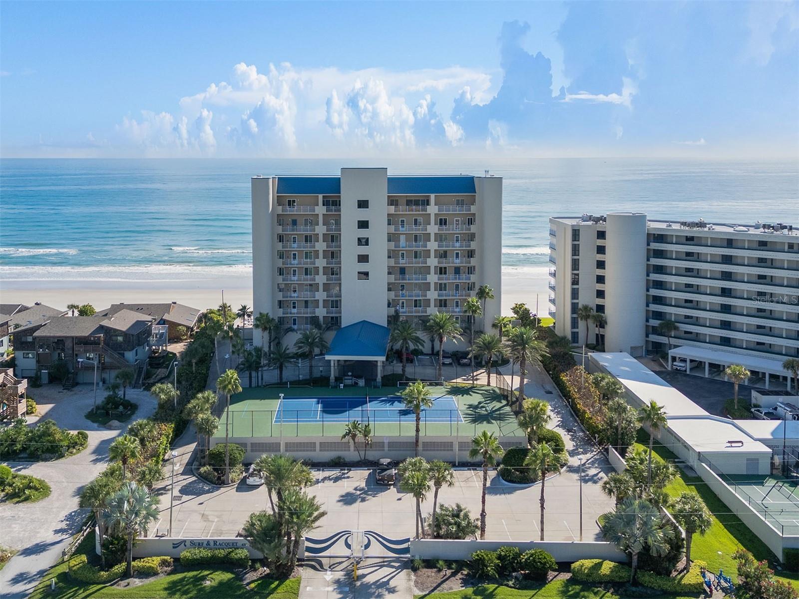 Beautiful direct oceanfront eighth-level condominium that has been updated by owners. This four-bedroom, or three-bedroom with den, 3-baths condo spans over 2,900 square feet and occupies a desired corner position, providing breathtaking views. The open kitchen, overlooking the great room, features walls of windows that flood the space with natural light and showcase the unrestricted ocean vistas. The spacious primary suite boasts glass sliders that open onto the expansive balcony, offering serene ocean views. The newer designed spa-like bath is adorned with exquisite finishes and includes generous closets. Two additional bedroom suites also offer private en-suite baths, walk-in closets and balcony access via glass sliders. Step outside to the impressive wraparound balcony, where you’ll relish sweeping views of the Atlantic Ocean and enjoy morning sunrises and evening sunset glows. In the luxurious Surf & Racquet Club, a gated community on the sought-after no drive section of New Smyrna Beach, this residence offers exclusive access to a heated beachfront pool, under-building parking, lighted tennis courts, a clubhouse and a fitness facility. Wonderful opportunity to find a more turnkey unit that shows as well as this one.