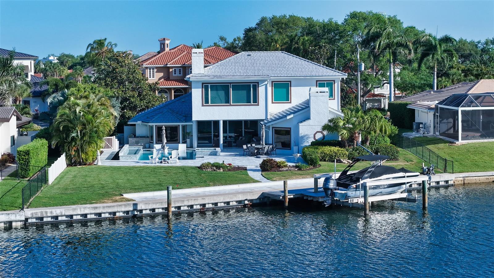 Just three homes in from the open waters of Little Sarasota Bay, this beautifully updated waterfront residence in Southpointe Shores offers a rare combination of location, scale, and immediate livability. Positioned on a quiet cul-de-sac with nearly 100 feet of Intracoastal frontage, the property captures wide water views and direct boating access in one of Sarasota’s most desirable neighborhoods. 
Spanning more than 4,500 square feet across two levels, the home is designed for both everyday comfort and entertaining. An open layout defines the main level, where wood-grain tile flooring connects the primary living spaces and walls of pocketing sliding glass doors open fully to the outdoor living areas—creating a seamless indoor-outdoor experience. 
The recently reimagined pool deck serves as the centerpiece of the home’s outdoor setting, featuring a covered lounge area, summer kitchen with built-in grill, and a resort-style heated pool and spa with sun shelf and waterfall features. The expansive patio overlooks peaceful waters, offering a dynamic waterfront backdrop from morning through sunset.
Inside, the new chef’s kitchen has been thoughtfully updated (in 2024) with custom contemporary cabinetry, quartz countertops, high-end appliances—including a built-in Miele coffee station—center island with breakfast bar, and a full-sized wine cooler. The adjacent family room offers vaulted ceilings, water views, and a well-appointed wet bar with built-in shelving, creating a natural gathering space.
Two guest suites with updated en-suite baths are located on the main level, along with a dedicated laundry room. The second floor is reserved for privacy, featuring an expansive primary suite with sweeping water views, fireplace, custom walk-in closet, and a marble en-suite bath. A study and additional bedroom on this level provide flexibility for a home office, fitness space, or nursery.
Recent upgrades enhance both comfort and peace of mind, including impact windows and sliding glass doors (2020), a new seawall (2019), tile roof (2016), updated electrical wiring, modernized baths, and newer HVAC and water heater systems.
Set on an oversized waterfront homesite with direct access to the Intracoastal Waterway, this boater’s sanctuary includes a newer private dock with 27,000-pound lift, accommodating a variety of boating needs. 
Southpointe Shores is a quiet, tucked-away waterfront community known for its proximity to Sarasota’s best coastal destinations. Siesta Key Beach and Crescent Beach are just minutes away, along with marinas, parks, and everyday conveniences. Downtown Sarasota’s cultural attractions—including The Bay Park, Selby Gardens, the Van Wezel Performing Arts Hall, galleries, and dining—are easily accessible, offering a lifestyle that balances privacy with connectivity.