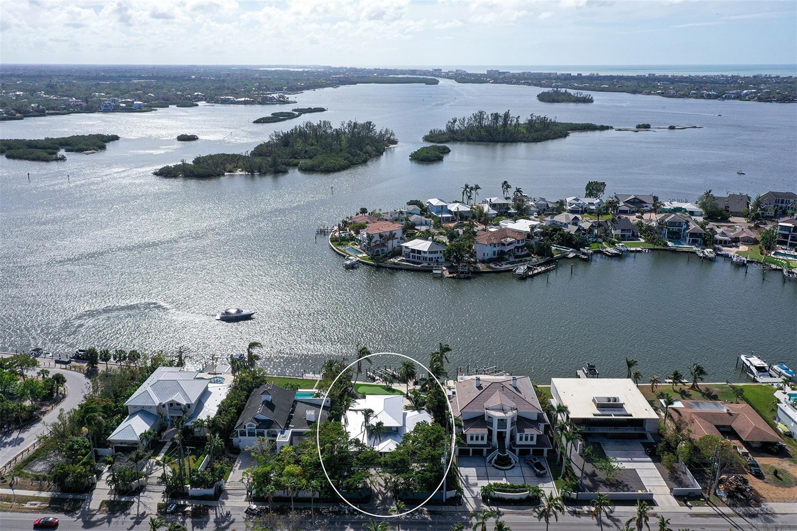 Now is the perfect opportunity to build your dream home on the highly sought-after north end of Siesta Key!  This prime property boasts wide, breathtaking water views and deep-water, ideal for boating enthusiasts. The expansive lot spans over 1/3 acre, offering plenty of space to create a custom retreat. The home is gated with a paver courtyard, beautifully landscaped and includes an outdoor kitchen and entertainment bar off the inviting pool.  Crafted for boating aficionados, the home features two docks/lifts—one rated for a 20,000 lb boat and the other for your run-about bay boat.  For the serious boater looking for wide deep waters and quick access to the Gulf of Mexico, this is the perfect place to call home.  Enjoy the ultimate combination of location and convenience, with easy access off the island and just moments to the beach.    Don’t miss out on this rare opportunity to own a prime piece of Siesta Key paradise!