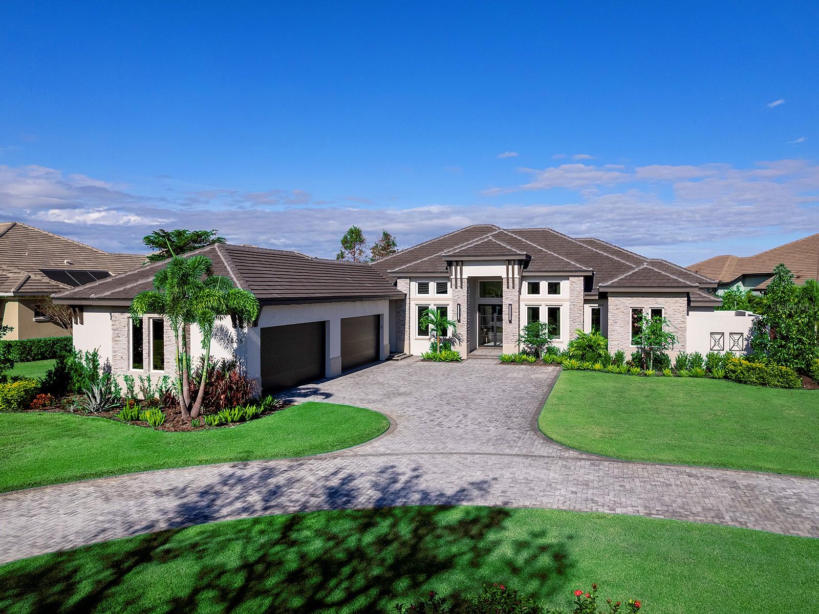 This home is being offered fully furnished, 2023 custom-built home is one of the most elegant and luxurious in The Concession. It sits on an oversized lot with a circular paver driveway and upgraded landscaping with lighting. The stone contemporary façade with lighting creates a striking entryway, leading to impact-glass front doors. The great room boasts a vaulted ceiling with beams, a stone accent wall with floating shelves and a sleek linear fireplace, upgraded surround sound and a wall of pocketing sliders. The open dining area features a dry bar with a quartz countertop, cabinetry and a wine cooler. The kitchen boasts ceiling-height cabinetry and stainless steel appliances including a True® refrigerator, Wolf® four-burner gas cooktop, wall oven, microwave, and a vent hood. Two Cove® dishwashers and a farm sink are positioned beneath expansive windows. The oversized island has quartz countertops, seating, cabinetry, a prep sink, and designer pendant lighting. Spacious pantry offers rain-glass cabinetry, quartz countertops and an additional refrigerator. The versatile bonus room features a custom ceiling with beams, zero-corner pocketing sliders, and designer wallpaper. The office has built-ins, and barn doors. The primary suite features a designer chandelier, large windows and a glass door that provides private access to the lanai. An oversized, custom-organized walk-in closet completes the space. The marvelous bathroom features a vaulted ceiling with beams, an oversized shower with 4 showerheads, stunning tile with a pebble inlay while the freestanding soaking tub is positioned near large windows. The expansive floating vanity with lighting below has two sinks, Zodiac® quartz countertops and gold hardware. 2 guest suites each have walk-in closets and en-suite baths with impressive vanities and Zodiac® quartz countertops. Sliding glass doors lead to a private courtyard. Two well-appointed guest suites complete the residence. A spacious guest casita offers a full bathroom with a vanity with two sinks, quartz countertops, lighted mirrors, and a glass shower with custom tile. There is also a wet bar with custom cabinetry, quartz countertops, and a beverage cooler. The shellstone lanai has an outdoor kitchen with an Alfresco® grill, a vent hood, a beverage cooler, and a sink, granite countertops, a tile backsplash, and pendant lighting. The heated saltwater pool and spa is complete with a sun shelf. The panoramic screen offers a lake view from the dining and lounging areas. The convenient pool bath has a vanity with quartz countertops and a shiplap accent wall. The laundry room has 2 washers and dryers, a stainless-steel farm sink, an ice maker, quartz countertops, ample cabinetry, and folding and hanging areas. The valet near the garage features a custom drop-off area with a bench and a shiplap accent wall. This home is further improved with custom, soaring ceilings with crown molding throughout, designer window treatments, luxury vinyl plank flooring in the main living areas and bedrooms, a whole-house generator, ample storage, remote-controlled lighting and shades, isocyanate insulation, and a whole-house reverse osmosis system. There is a contractor warranty through October 2025. The Concession, home to the 2021 PGA Tour World Golf Championship and the 2023 PGA World Champions Cup, is one of the most prestigious golf communities in the country and provides the perfect setting for those who admire a serene and tranquil environment.