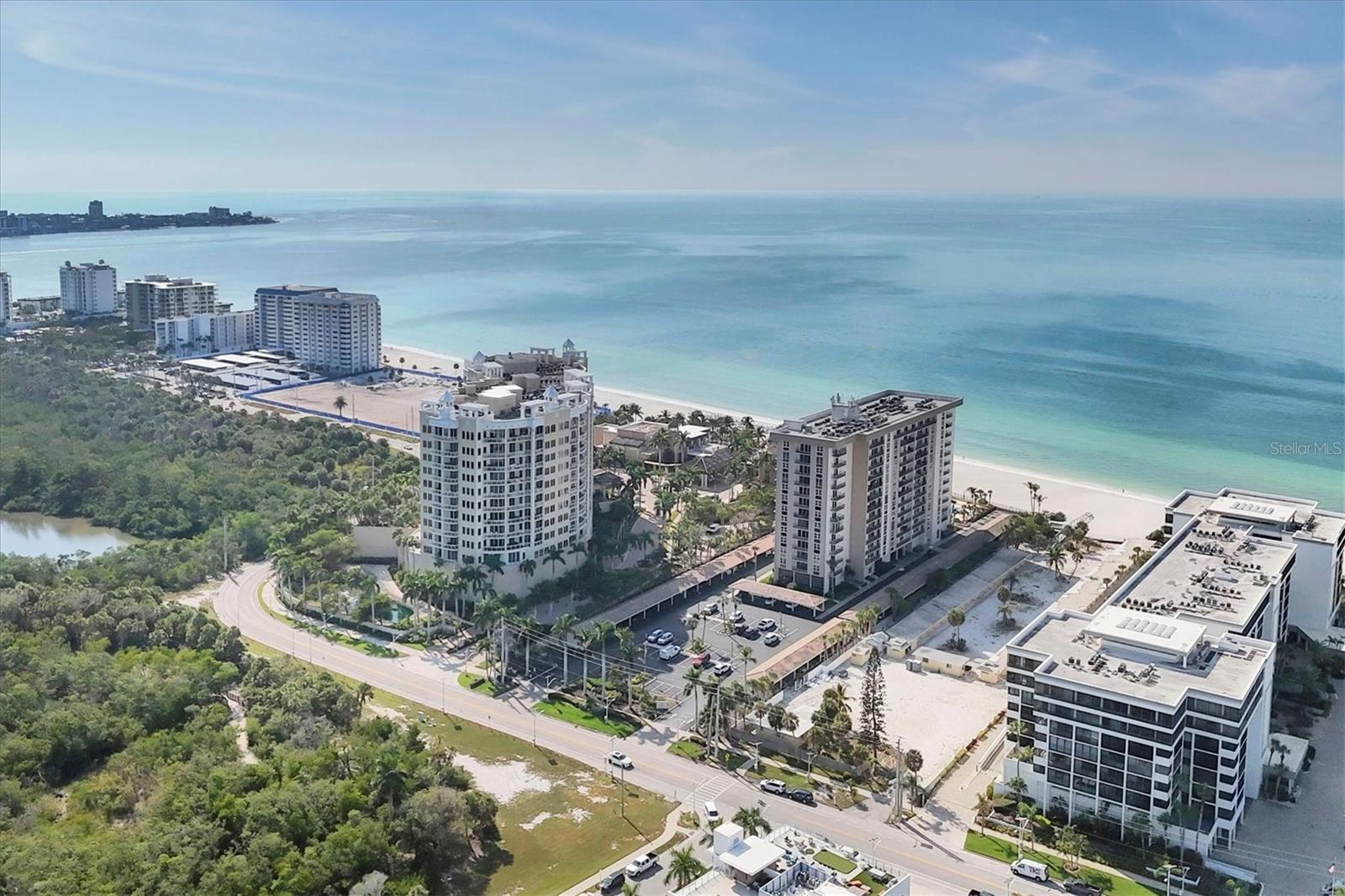 WELCOME to LIDO BEACH CLUB, one of Lido Key’s most beloved and beautifully maintained Gulf-front communities. Perched on the 10th floor, this 1,421-square-foot residence at 1212 Benjamin Franklin Drive, Unit 1003, delivers beach views of the Gulf of Mexico, Sarasota Bay, and the sparkling coastline beyond — visible from every room. This bright, airy condo offers two spacious en-suite bedrooms, each generous enough to serve as a primary retreat. Luxury vinyl plank and tile flooring run throughout, giving the home a clean, cohesive feel. The open gathering areas are centered around the panoramic scenery, showcased through walls of glass accented by wood-framed sliding plantation panels. Step outside to the 30-foot balcony, wrapped in wrought iron for that timeless coastal touch. From here, enjoy gentle breezes, sweeping vistas, and even a peek at the Ritz-Carlton Beach Club next door. Florida living doesn’t get much finer. The kitchen features granite countertops, a stainless three-door refrigerator, new microwave, and solid cabinetry with pull-out drawers and a pantry. The counter’s peninsula design allows for barstool seating — perfect for casual bites or chatting with company while you cook. A convenient in-unit stackable washer and dryer adds everyday practicality. Both bathrooms have been tastefully remodeled with quartz countertops, integrated sinks, and updated showers with a newer hot water heater to ensure you have dependable hot water and energy-efficient comfort for years to come. This tropical oasis is being sold turnkey furnished. Lido Beach Club itself sits right on the sand, offering a private beach, a beachside pool, tiki tables, grilling areas, and front-row seats to Sarasota’s postcard-perfect sunsets. Additional community features include a large club room perfect for parties and gatherings, fitness center, and recently renovated hallways with a stylish, contemporary look. An on-site property manager rounds out the peace of mind. All of this comes with unbeatable walkability to the world famous St. Armands Circle and a quick hop over the John Ringling Bridge to downtown Sarasota, where dining, theater, arts, and entertainment await.