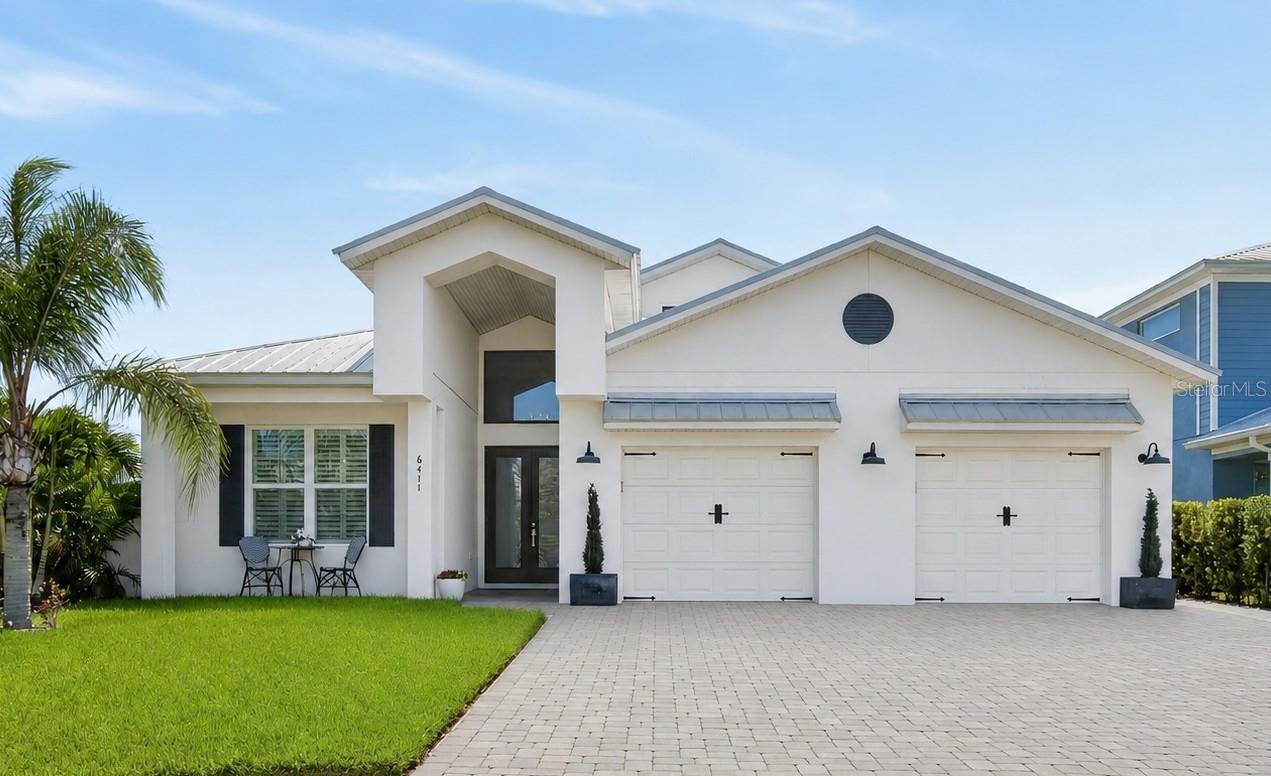 APOLLO BEACH - MULTIGENERATIONAL CUSTOM BUILT KEY WEST EXECUTIVE POOL HOME: Vacation all year round in this custom-built pool home located in the very desirable, gated, coastal community of Bimini Bay! This luxury pool home is move-in ready with a fantastic floor plan that features a separate living area (in-law suite) with a private entrance, perfect for long-term visitors, a live-in caregiver, or an adult child returning to the nest. This bright and spacious, 4-bedroom, 3-bath, 2,491 sq. ft. luxury home with a 2-car garage with epoxy flooring was built in 2022 by Schmidt Construction Group for family fun and entertaining. Upon entering through the 8 ft. frosted glass doors into the foyer, your eyes are drawn to the 14.5 ft. high ceiling and the abundance of natural light streaming through the large transom window that accentuates the great room, dining, and kitchen area of this open concept floor plan. This gorgeous home features no carpet in the main living area, 10 ft. high walls rising to the cathedral ceilings, 8 ft. doors, and high-quality wood-look plank tile throughout (including the lanai), an electric fireplace accented by a shiplap media wall, and beautiful plantation shutters that perfectly capture that Key West feel. There is a Chef's kitchen boasting upgraded stainless-steel appliances, white 42" wood cabinets with slow-close drawers, and crown molding. It also features high-end granite countertops, breakfast bar seating, a pot filler, coffee bar, and comes complete with a classic, wall-mounted stainless steel hood vent. The Master Retreat is spacious, with high ceilings, plenty of natural light, and features a walk-in closet with custom cabinetry. There is an appointed en-suite offering high-end quartz counter tops, a linen closet, a vanity, and a large custom shower featuring two shower heads, a hand shower, and a shower footrest. The two secondary bedrooms in the main living area are bright and offer generous accommodations. Bedroom #3 is currently being used as a home office. The great room perfectly flows into the backyard oasis, featuring a 21'x11' lanai with wood-look plank tile, wood shiplap ceiling, summer kitchen, ceiling-mounted fans and heaters, and a retractable screen. A fenced yard with luminous LED lighting surrounds a beautiful heated pool. The pool features LED lighting, sun shelf loungers, and two waterfalls, and is centered in a beautiful brick paver patio. The secondary living area (in-law suite) features private exterior access and garage access, bedroom #4, a full kitchen, and a full bathroom with quartz countertops, a living area featuring a cathedral ceiling, a walk-in closet, a washer/dryer hookup, and single-car garage access. Known to locals as the "Jewel of SouthShore," Bimini Bay is a centrally located waterfront community of 157 Key West style homes. It offers a community clubhouse and pool, NO CDD, and a very reasonable HOA. Bimini Bay is conveniently located and offers easy access to everything the Tampa Bay area has to offer. This exceptional property combines luxury, comfort, and convenience in one remarkable home. Make your Florida dream a reality.