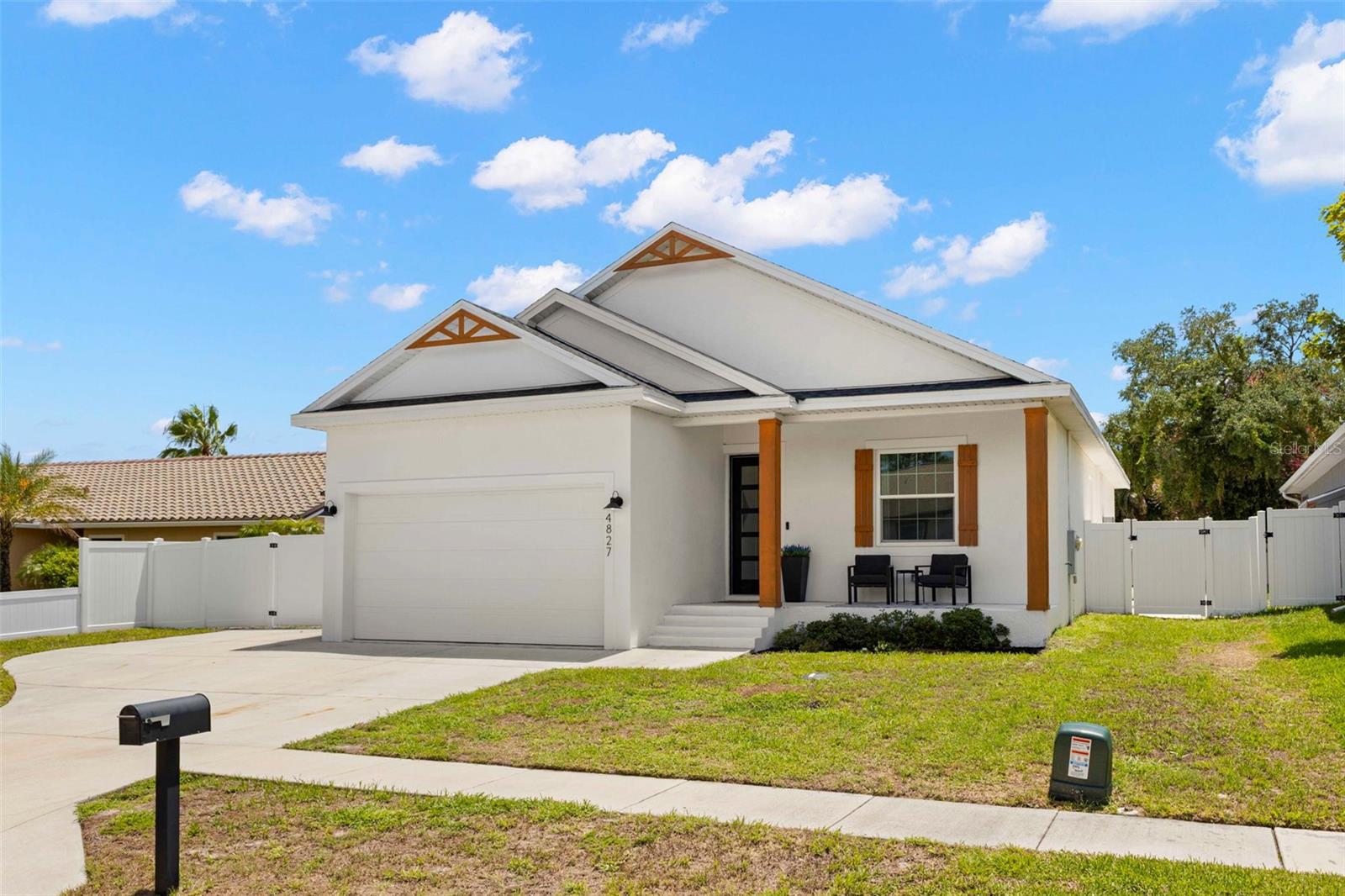 Modern Coastal Retreat with Resort-Style Backyard in the Palm Harbor neighborhood of Blue Jay Woodlands! NO FLOOD INSURANCE REQUIRED. Built in 2022, this beautifully updated 3-bedroom, 2-bath pool home blends clean modern style with true Florida outdoor living. A crisp white exterior with warm wood-tone accents and a covered front porch set the tone the moment you arrive. Just inside the front door, a mudroom-style foyer welcomes you home with a built-in bench, and wall hooks for coats and bags, a thoughtful, functional touch as you come and go. From there, luxury vinyl plank flooring flows throughout the entire home for a seamless, low-maintenance living space. Soaring 10-foot ceilings, 8-foot doors, and custom baseboards throughout add to the home's open, elevated feel. The open-concept kitchen is a showstopper, featuring a large pantry, crisp white shaker cabinetry, quartz countertops, a herringbone tile backsplash, a large center island with seating for four, farm style sink, and a stainless steel propane range. A dedicated bar area with open shelving and stainless refrigerator adds extra entertaining space just off the kitchen. The kitchen flows effortlessly into a spacious living area anchored by a shiplap accent wall with an electric fireplace and mounted TV — perfect for cozy nights in or hosting guests. Sliding glass doors (impact-rated, like all windows in the home) bring in natural light and lead directly to the outdoor oasis. The primary suite offers a generous walk-in closet with custom built-in shelving, plus an en-suite bath with a frameless glass walk-in shower, dual vanity, and designer subway patterned tile flooring. Two additional bedrooms offer flexible space for family, guests, or a home office/gym, and a stylish guest bath features a brass-finished mirror and fixtures with a soaking tub/shower combo. Step outside to your private backyard paradise: a heated salt water pool with a built-in sun shelf and heated spa, a cozy fire pit area for cooler evenings, surrounded by pavers and a low-maintenance rock landscape. A custom wood-built gazebo bar with seating, a sink, mounted TV, ceiling fan, and string lighting makes this the ultimate spot for entertaining or unwinding after a long day. The fully fenced yard offers privacy with a mix of white vinyl and painted block fencing. Additional features include a 2-car garage, tankless propane water heater, and propane pool heater for efficient, on-demand comfort. Smart system controls for the thermostat, pool pump, and many other features. This home is designed for both everyday living and effortless entertaining. Close to everything the area has to offer including downtown Tarpon Springs, downtown Dunedin, Pinellas Trail, and Honeymoon Island State Park. Minutes to great shopping and restaurants. Schedule your showing today!