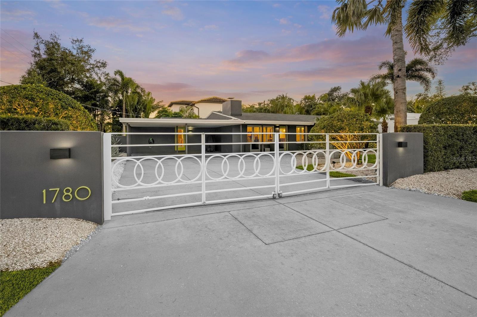 Architectural character, curated design, and resort-style outdoor living define this exceptional Sarasota residence at 1780 Spring Creek Drive.
Privately positioned behind a gated entry  and surrounded by lush tropical landscaping, this distinctive home offers a refined Florida lifestyle with thoughtful upgrades, timeless style, and true peace of mind. Located in one of the the location that Sarasota has to offer. 

Inside, the home welcomes you with soaring ceilings accented by exposed beams, expansive windows, and an open, light-filled layout that blends modern design with everyday comfort. Warm wood tones, clean architectural lines, and carefully selected finishes create a sophisticated yet relaxed ambiance throughout the main living spaces.

The updated kitchen is designed for both beauty and function, featuring luxury appliances, sleek cabinetry, stone countertops, and a statement glass-topped bar, ideal for entertaining or casual dining. The kitchen flows seamlessly into the living and dining areas, creating an inviting environment for gatherings large and small.

The primary suite serves as a private retreat, offering tranquil garden views, direct access to the outdoor living area, and a spa-inspired bath adorned with striking mosaic tile, modern fixtures, and a glass-enclosed walk-in shower. Additional bedrooms are thoughtfully arranged to provide flexibility for guests, a home office, or creative space.

Step outside to the screened lanai and resort-style pool and spa, where privacy and lush landscaping create a serene oasis. Recent upgrades include a new pool filter, enhancing efficiency and ease of ownership, while covered seating areas invite year-round outdoor enjoyment.

Beyond its aesthetic appeal, this home is equipped with premium infrastructure upgrades designed for long-term comfort and reliability. A Generac natural gas generator powers the entire home and pool, providing seamless backup during outages. The roof is approximately six years old, plumbing lines have been professionally blown out and cleaned, and the property is located in a no flood zone for added peace of mind. The home is serviced by city water, complemented by a deep water irrigation well that keeps the lush landscaping thriving while helping reduce utility costs.

Aerial views highlight the home’s generous lot, mature greenery, and prime Sarasota location—just minutes from downtown Sarasota, world-renowned beaches, shopping, dining, and cultural attractions.

Distinctive, upgraded, and effortlessly livable, 1780 Spring Creek Drive delivers a sophisticated Sarasota lifestyle without compromise.