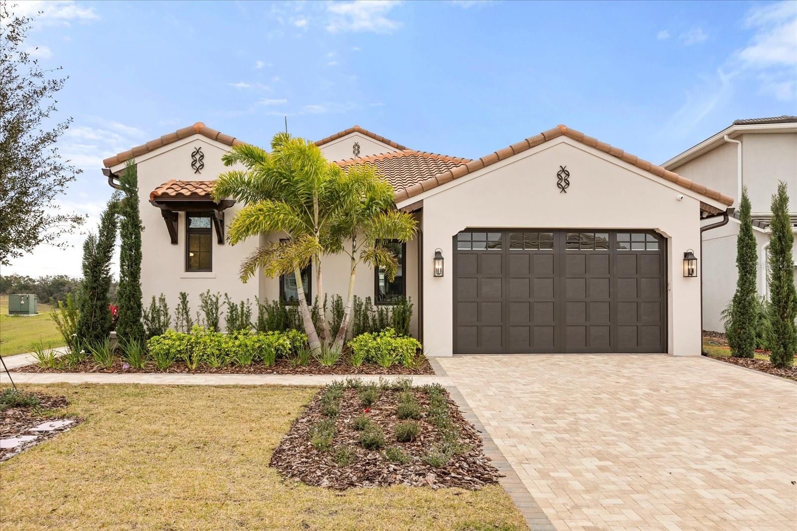 A truly rare offering on the Golf side of Bella Collina, this newly completed residence by Vogel Building Group is one of only a select few single-story homes in this coveted enclave. Set on a quiet cul-de-sac, the home enjoys added privacy with no neighboring home along the side of the front entry, creating a sense of openness seldom found on the Golf side.

Architectural distinction begins at arrival with a side-entry design and an uncommon single, oversized garage door, a refined and modern departure from the traditional dual-door façades throughout the community.

Inside, elevated craftsmanship defines the living spaces. Soaring ceilings with exposed wood beams crown the expansive great room, which flows effortlessly into the dining area and a showpiece kitchen. Designed for both performance and presence, the kitchen features Wolf and Sub-Zero appliances, a dramatic oversized island, custom cabinetry, and curated finishes that balance warmth and clean-lined design.

A beautifully appointed butler-style laundry room enhances daily living with abundant cabinetry, washer and dryer, a utility sink, and generous workspace - ideal for both organization and entertaining support.

The home features four bedrooms total, each with its own ensuite bath and walk-in closet, offering exceptional privacy and flexibility. One of the bedroom suites is currently styled as a home office, providing an ideal work-from-home environment while maintaining full guest or bedroom functionality.

The private primary suite serves as a serene retreat, featuring volume ceilings, abundant natural light, and tranquil views. The spa-inspired primary bath includes dual vanities, a freestanding soaking tub, an expansive glass-enclosed shower with multiple shower heads, and refined finishes throughout. A custom walk-in closet completes the suite.

In addition to the ensuite baths, the home includes a stylish interior powder room for guests, as well as a separate half bath conveniently located off the lanai, ideal for pool and outdoor entertaining.

Outdoor living is equally impressive. Large sliders open to a covered lanai featuring a fully equipped outdoor kitchen, motorized screens, and a beautifully designed pool and spa - ideal for year-round enjoyment. The rear of the home faces southeast, capturing soft morning light and comfortable afternoon shade, while open views surround the property, enhancing privacy and connection to the natural landscape.

Located within the guard-gated community of Bella Collina, residents enjoy access to a Nick Faldo–designed championship golf course, Har-Tru tennis courts, pickleball, a full-service spa and fitness center, multiple dining venues, and a vibrant social calendar. The developer will defer the $40,000 Sports Membership deposit at closing, offering an added benefit to the buyer.

Single-story homes of this caliber on the Golf side are exceptionally rare. This move-in-ready Vogel residence offers architectural distinction, refined luxury, and a premier setting in one of Central Florida’s most exclusive private communities.