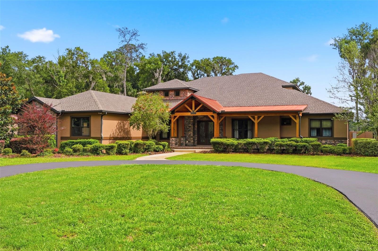 A rare opportunity to own an extraordinary waterfront estate on 15+ private acres, thoughtfully designed with exceptional craftsmanship, luxury finishes, and resort-style amenities throughout. Behind the private gated entrance, this impressive residence offers nearly 6,000 living square feet of refined living space surrounded by peaceful natural beauty and stunning views of Lake Shoe. A welcoming timber-framed front porch and dramatic double iron entry doors set the tone for the home’s elevated design. Inside, engineered wide-plank oak flooring flows throughout the main living areas, complemented by rich stone accents and custom details. The private office creates the perfect work-from-home retreat, while the open-concept living spaces are designed for both everyday comfort and unforgettable entertaining. The expansive great room, gourmet kitchen, and game room seamlessly overlook the spectacular pool oasis featuring a striking cypress tongue-and-groove ceiling. The chef’s kitchen is truly exceptional, offering extensive custom cabinetry, dual pantries, two sinks, Wolf double convection ovens, reverse osmosis, a Sub-Zero refrigerator/freezer, and a Wolf gas plus induction range with custom hood. Entertaining is effortless with a fully equipped wet bar featuring a sink, ice maker, and beverage center adjacent to the spacious game room. 
Begin your mornings in the luxurious upstairs primary bedroom, enjoying coffee from your private balcony overlooking the sparkling pool and peaceful lake views. From there, head downstairs to your fully equipped home gym before unwinding in the spa-inspired primary bath, featuring a spacious walk-in shower with dual heads, rain shower, and body sprays, along with a soaking tub, separate vanities with a dedicated makeup area, and an oversized custom closet.  Guest accommodations are thoughtfully designed with privacy and comfort in mind. A central flex lounge connects two guest suites via a Jack-and-Jill bath, while another guest bedroom enjoys its own private full bath. There is also a stackable washer and dryer in this area. Don't forget the upstairs media room wired for surround sound and projection.
Additional highlights include an oversized side-entry garage with two 18x10 doors, whole-home generator, extensive water filtration system, central vacuum system, custom LED accent lighting, and extensive concrete parking. The detached 60x40 insulated metal building offers three bays, electrical service, elevated storage, and a 50-amp RV hookup — ideal for hobbies, recreational vehicles, or additional storage. Could also be converted to barn. Equestrian enthusiasts will love the adjoining 2 paddocks with four board fencing. Combining privacy, luxury, recreation, and functionality, this exceptional estate delivers a truly one-of-a-kind waterfront lifestyle.