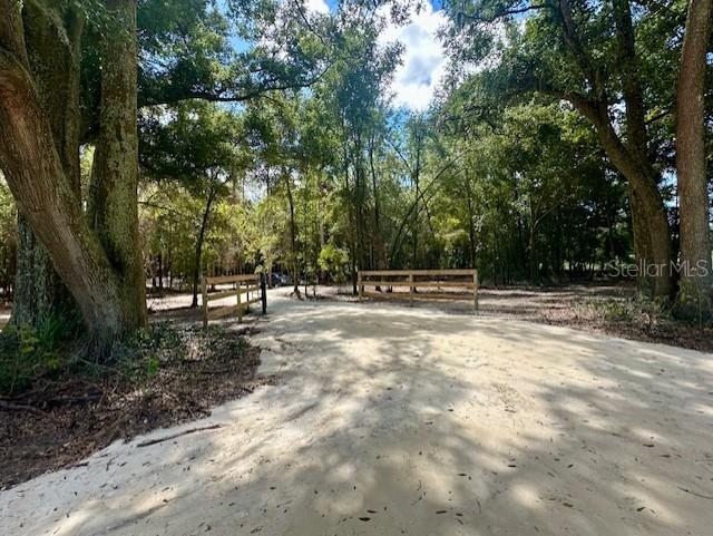 9 BEAUTIFUL ACRES just south of BELL, FL near the Gilcrest Training Center harness racing track. Are you looking for the perfect location to build or place your dream home, start a new homestead or mini-farm, or invest in land with endless potential?! This stunning 9-acre parcel offers just that! Mature oaks and native hardwoods blanket much of the property providing shade, character, and a true sense of privacy. A cleared entrance and established drive make for easy access, and the gated entry adds both convenience and security. A recent survey to be provided. High and dry property! No deed restrictions and no HOA. Come discover what the peaceful country setting is truly like. Located in Gilchrist County with low property taxes and "A" rated schools. Several rivers and freshwater springs nearby. Conveniently situated between Bell and Trenton, with just a short drive to either and within a 30-minutes drive to Newberry, Alachua, or High Springs. Or travel just under an hour to Gainesville or Lake City, perfect for a day trip or to pursue employment or education opportunities. Come see this property for yourself! Conveniently located adjacent to the Gilcrest Farms Training Center