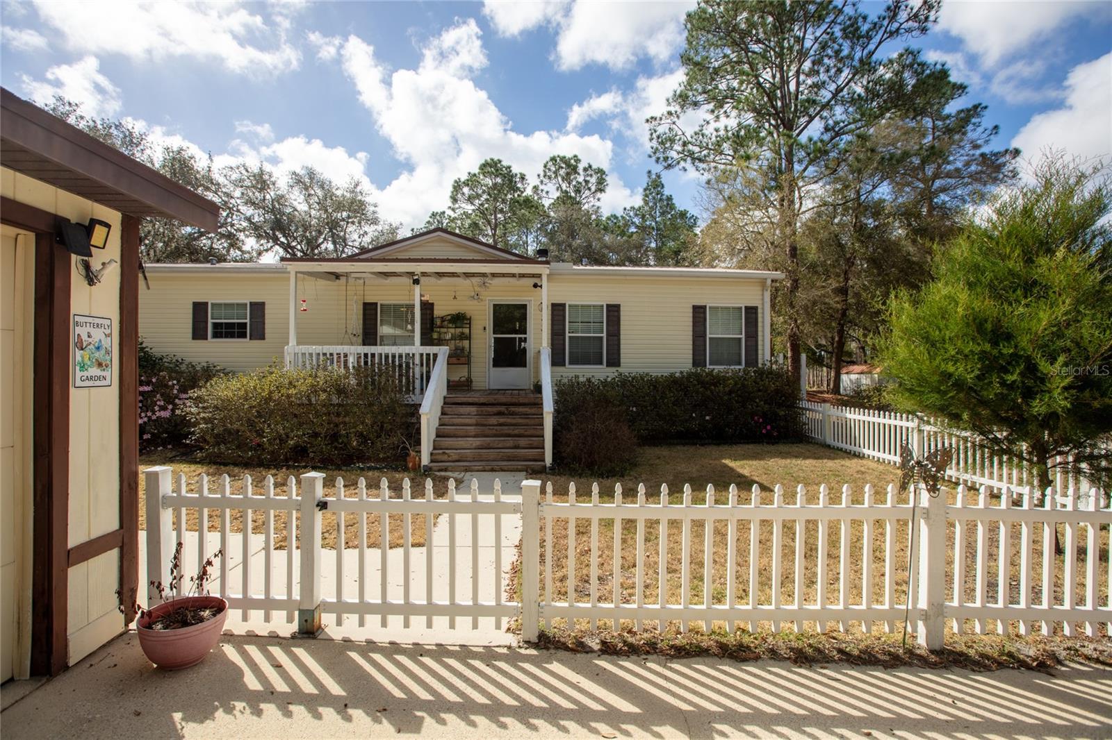 Enjoy peaceful living at this well maintained 2014 manufactured home which offers 3 bedrooms and 2 full baths. Features include a wood burning fireplace, and a large functional kitchen with walk-in pantry and 2 ovens. Upgraded tray ceilings, drywall interior, crown molding, and widened interior doors. Large master bathroom equipped with grab bars. The spacious laundry/utility room includes a sink and cabinets for storage. Enjoy outdoor living from the covered front porch or the back deck with a half covered roof. Property includes a 2 car detached garage with an attached office or workshop space equipped with A/C, a 16'x24' garage/workshop with 220 amp service, and an aluminum shed for additional storage. Outdoor amenities include a gazebo and private dock overlooking Smith Lake. Located in Big Tree Lakes just outside of town, minutes away from local restaurants, shopping, Gold head State Park, Keystone Beach, and the airport. Centrally located for easy commute to Jacksonville, Gainesville, or Palatka. HVAC replaced 2022.