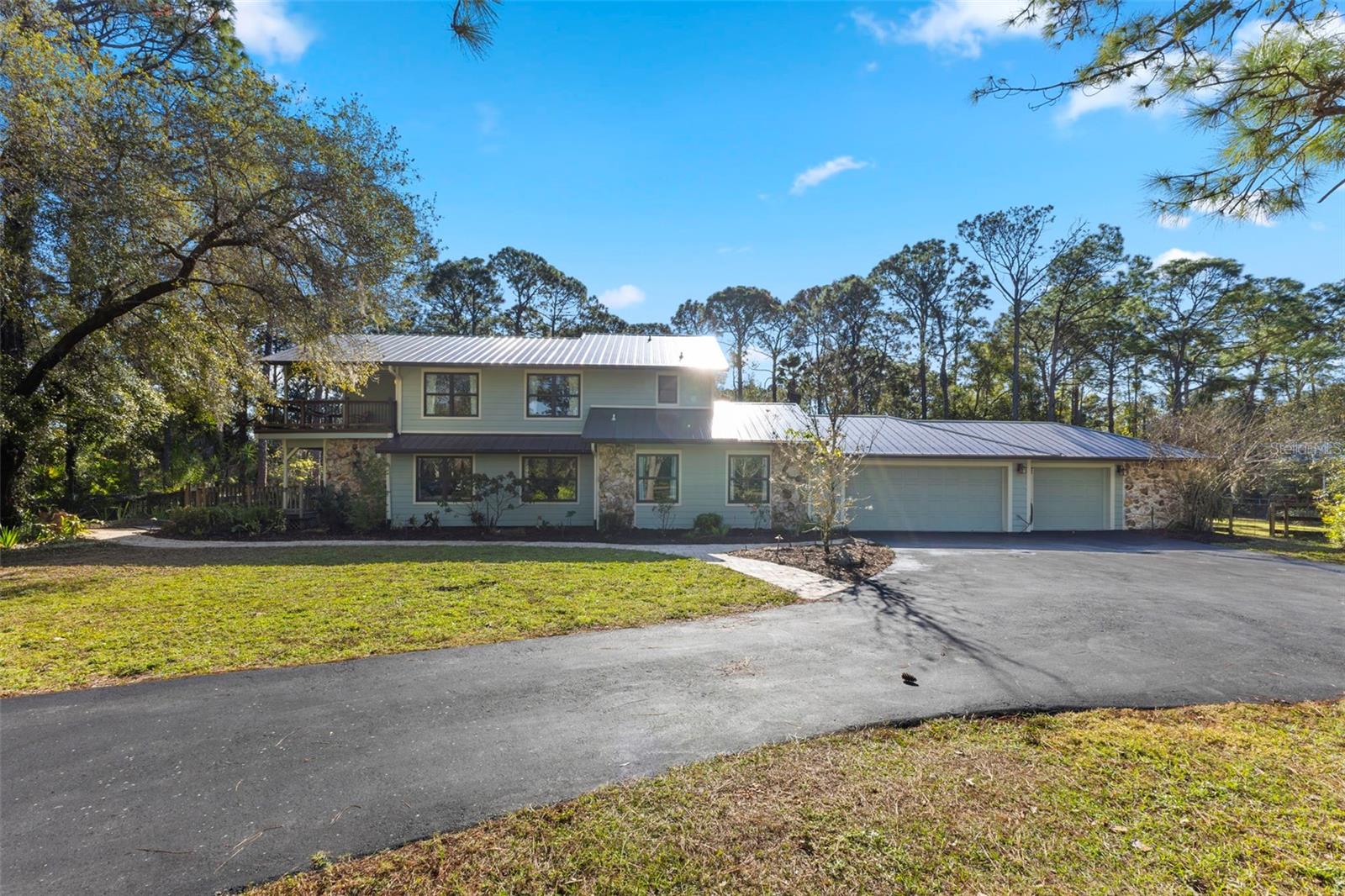 A PREMIUM HIDDEN LOCATION WITH CONVENIENCE AND PRIVACY! These private acreage lots allow up to three structures on the property—build an ADU, add a large workshop, and still have room to create whatever you envision. Endless possibilities await! This exceptional estate is set on more than five fully fenced acres of beautifully manicured, lush grounds. Tucked away, you will enter through a winding, tree-canopied driveway. Welcome to “The Ranch at Pine Acres ” a five-bedroom residence, where complete privacy and peaceful natural surroundings create a country feel. Delight in the endless possibilities of this private home in Pine Valley Ranches. This hidden gem is perfectly positioned on the most desirable 5-acre lot in this exclusive community, offering the perfect balance of tranquil country living and easy access to I75, Sarasota’s downtown, University Town Center, Waterside, and the renowned Gulf beaches. The main home offers nearly 4,000 square feet of professionally designed living space, with expansive views from every window of this private estate. This unique property is move-in ready. Recent upgrades include a new metal roof on both the home and barn, pavered walkways and patio, wood and Trex decking, a large saltwater pool, three air-conditioning systems. Impact windows and French doors throughout offer abundant natural light with cedar plank tongue-and-groove vaulted ceilings. At the heart of the home, the gourmet kitchen flows seamlessly into the formal dining room and is open to the oversized great room that has a beautiful wood-burning fireplace with specialty coquina stone. Designed for both function and style, the kitchen showcases rich 5/4" cherry cabinetry with under-cabinet lighting, multiple copper farm house sinks, imported granite countertops, Mulga White Turkish marble backsplash extending to the ceiling, built-in appliances including a cabinet-faced KitchenAid refrigerator, Miele built-in oven, THOR induction cooktop, Bosch dishwasher, GE infrared microwave and an exceptionally spacious butler’s pantry with even more storage. A large multipurpose room with laundry area provides flexible space for a playroom, office, or additional family room or storage. The generous primary suite overlooks the front picturesque grounds with its private balcony/deck. This second-level retreat features a luxurious Indian Rainforest marble bathroom fully equipped with a soaking tub and large shower, dual walk-in closets, and beautiful oak floors. A second two-room suite completes the upper level. Adjacent flex space is ideal for an office, playroom, or additional bedroom overlooking the trees of “The Ranch at Pine Acres ”. Three additional bedrooms are located on the first floor, offering comfortable accommodations for a large family and/or guests. Attached 3-car oversized garage with a hurricane room and RV hookup. Adding to the property’s versatility is a massive, detached barn featuring a horse stall, workshop, tack room, generous storage space, two more RV hookups, and a surrounding horse paddock—ideal for equestrian use, recreational vehicles, or additional storage. A Sarasota premier location...where private acreage meets the charm of country life... yet right in Sarasota!