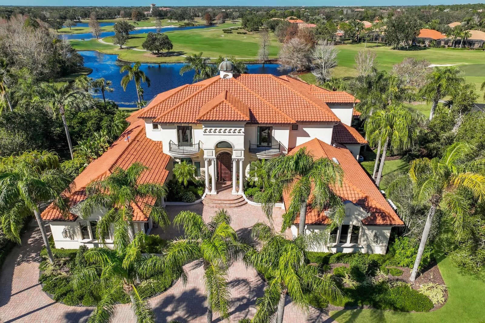 An unparalleled opportunity awaits in Lakewood Ranch on one of the most breathtaking lake and golf front settings in this re-imagined 6 bedroom suite residence that epitomizes the notion of a rare find. Positioned on .66 acre in the sought-after enclave of Portmarnock in The Country Club, this fully remodeled residence delivers 8,663 square feet of flawless excellence showcasing generously proportioned spaces, exceptional new design, superior Cat 5 rated impact windows/sliders/doors, the addition of smart home security, light and media, and even a new generator to power the entire home. Beyond the grand foyer and just off a formal dining room is the open living room with two-story coffered ceilings, gas fireplace with stone surround, and an all new wet bar with cabinetry, quartzite counters, tile backsplash, sink and Sub-Zero appliances. Family and friends will celebrate the resort-styled lanai boasting new lanai cage with clear view screen, heated pool/spa with new pebbletech surface, new outdoor kitchen, gas fireplace, new outdoor shower, remodeled outdoor bath, pecky cypress ceilings, all new outdoor lighting, and, of course, the surrounding vistas for an unmatched optic experience. Seamlessly connected to the serene outdoors via disappearing impact glass doors is an invitingly large great room open to the kitchen where form, function and design reigns cohesively with sprawling quartzite counters, wood cabinetry with dovetail soft-close drawers, designer tile backsplash, large island with storage and pull-out drawers, high-performance appliances, a butler’s pantry, an oversized hidden walk-in pantry, and a breakfast nook area adorned with the surrounding views. Continuing on main level, step into the home’s re-designed private theater with all new smart home media, cinema screen, and projector equipment. With health and fitness as a priority, an exercise room awaits newly done with mirrors, wood trim, ceiling fan, and cork flooring. Unwind in 2 elegant owner’s retreats each positioned on their own private wing on the main level, both offering walk-in customized closets, new engineered hardwood floors, direct lanai access, and one even boasts its own separate sitting room ideal as an office, den, nursery or gym. Both main level owner suites deliver luxuriously appointed spa-like baths with separate vanity stations and stand-alone showers, while one features its own sauna, the other a free-standing soaking tub surrounded by an orchid garden. Family and overnight visitors alike will be right at home on the upper level with 4 generously sized guest suites, all with private full baths and new engineered hardwood floors.  Additionally, the loft-style club room boasts an all new wet bar accentuated with stylish backsplash, waterfall style quartzite counters, wood cabinetry and Sub-Zero appliances. Other notable highlights of this 10,912 sf residence includes new irrigation system, new architectural and landscape lighting, circular driveway, generously updated laundry room, two remodeled powder rooms, 2 new tankless water heaters, central vacuum, solid interior doors, and a split 5-car garage. This one-of-a-kind offering is a testament to refined living within a renowned community known for its vibrant lifestyle near dining, shopping, polo, golf, tennis, community events and entertainment close to the UTC area, the culture and beaches of Sarasota, and of course, in an A-rated school district next to ODA and a few miles from IMG.