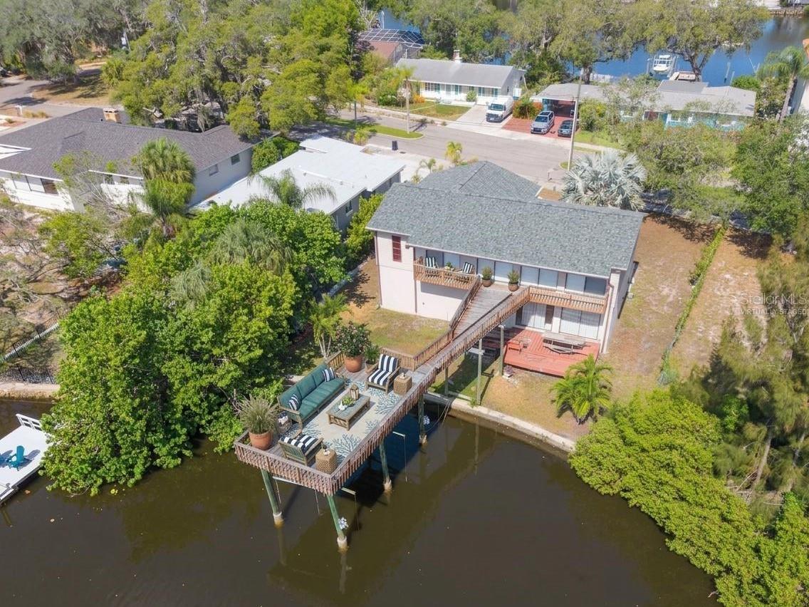 Virtually Staged. Seller says "Bring your best offer."  Experience the best of Florida waterfront living in this 3-bedroom, 2-bath elevated home overlooking the peaceful waters of Minetta Bayou with direct Gulf access. Perfectly positioned in one of Tarpon Springs' most desirable locations, this property offers the ideal combination of breathtaking water views, flexible living space, and the laid-back coastal lifestyle you've been dreaming of.

The elevated main living area features a spacious, light-filled open floor plan with a large living room, dining area, and an inviting kitchen complete with bright white cabinetry, generous counter space, and excellent flow for everyday living and entertaining. Step outside to the expansive elevated deck, where you'll enjoy panoramic views of Minetta Bayou while sipping your morning coffee, hosting gatherings, watching local wildlife, or taking in spectacular Florida sunsets.

The private primary suite and two additional bedrooms provide comfortable accommodations on the main level, while the home's new roof and hurricane shutters offer added peace of mind.

Downstairs, you'll discover an incredible bonus living area with its own second kitchen, making it ideal as a guest suite, in-law quarters, studio apartment, recreation room, home office, or expansive family room. A large storage closet and an oversized 3-car garage provide exceptional space for vehicles, tools, water toys, fishing gear, and all your outdoor equipment.

Boaters and nature lovers will appreciate the Gulf access from Minetta Bayou, offering endless opportunities for kayaking, paddleboarding, boating, fishing, and exploring Florida's scenic waterways.

Located just minutes from the world-famous Tarpon Springs Sponge Docks, historic downtown Tarpon Springs, Fred Howard Park and Beach, Sunset Beach, the Pinellas Trail, marinas, waterfront dining, boutique shopping, festivals, First Friday celebrations, live concerts, art shows, and year-round community events, this exceptional home places you in the heart of one of Florida's most charming coastal communities. With convenient access to Tampa International and St. Pete-Clearwater International Airports, you'll enjoy easy travel while living where others vacation.

Whether you're searching for a full-time waterfront residence, seasonal retreat, or the perfect home for entertaining family and friends, this exceptional Minetta Bayou property offers an unparalleled Florida lifestyle with endless possibilities.