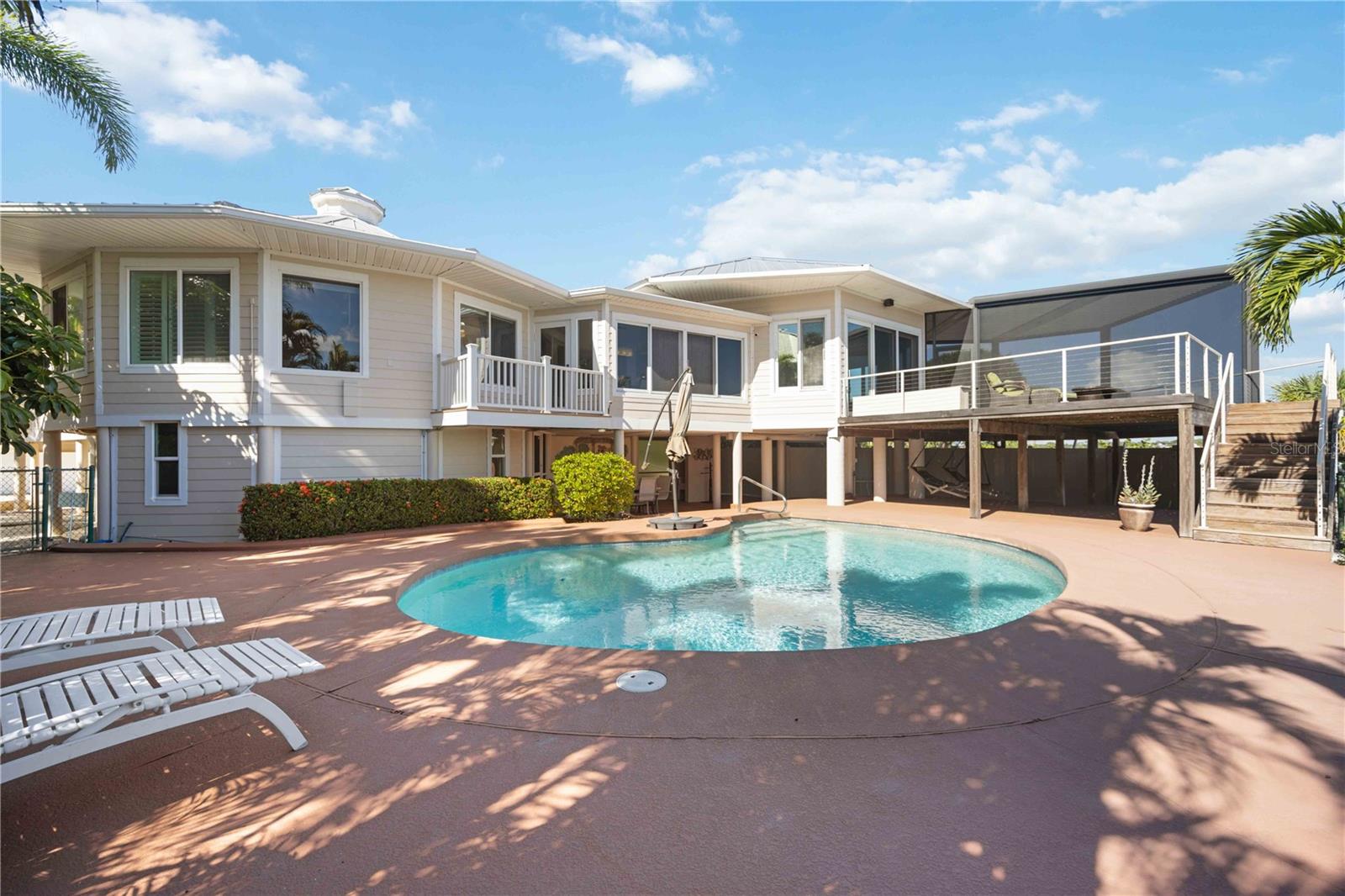 One or more photo(s) has been virtually staged. Welcome to your slice of paradise on Manasota Key! This stunning waterfront residence boasts an exceptional location on Lemon Bay with deeded access to a private Gulf of Mexico beach, providing an unparalleled coastal lifestyle. Situated on nearly an acre of land, this exquisite property offers an awe-inspiring open floor plan that showcases breathtaking 180-degree views of Lemon Bay.
Immerse yourself in the beauty of this uniquely designed architectural masterpiece, fully renovated in 2014 to embody both elegance and resilience. Designed for safety and serenity, the home is elevated on pylons to safeguard against storms. Upgraded with hurricane impact windows and doors throughout, including the garage, along with a durable metal roof, this home ensures both style and safety. A 3-car garage provides ample space for your vehicles and storage needs. Additionally, a portable generator provides peace of mind during any unforeseen circumstances.
The main living level epitomizes luxury living with 3 bedrooms and 2 bathrooms, complemented by a seamless open-concept layout. Entertain effortlessly in the formal dining room or cozy breakfast nook. The home features a cocktail bar complete with a Kegerator for pouring your favorite draft beers. The gourmet kitchen, adorned with Rain Forest Green Marble countertops and an island with seating for two, is a chef's delight. The expansive living room offers a serene ambiance to relax and relish the panoramic vistas of Lemon Bay.
Step outside to discover a resort-style experience with a gorgeous pool, sun deck, and a covered, screened-in porch featuring a louvered roof, perfect for embracing the Florida lifestyle.
The ground level is a haven for outdoor entertainment, offering two swing chairs, dining areas, an outdoor shower, and a convenient half bathroom. Abundant storage space on the ground level ensures effortless organization of outdoor essentials.
For water enthusiasts, a private dock equipped with a covered boat lift (7000lb lift capacity), power, and water access awaits you for your boating adventures.
Nearby, the Private Manasota Key Beach club awaits, offering tennis, dining, and stunning sunset views for your enjoyment.
This stunning home is being sold partially furnished, allowing you to effortlessly transition into coastal living. 
Don't miss this exceptional opportunity to own a luxurious retreat nestled in the beauty of Manasota Key, offering unparalleled waterfront living and remarkable amenities.