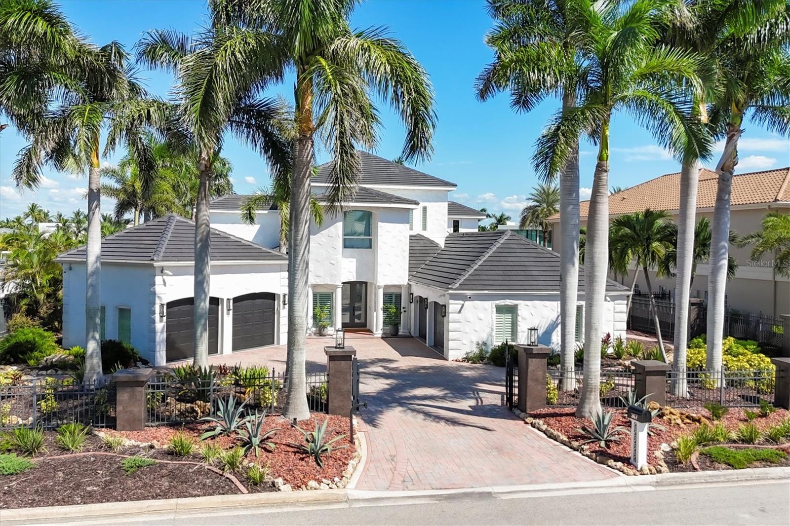LOWEST PRICE PER SQ FT FOR WATERFRONT PROPERTY ON BIRD KEY! A magnificent sanctuary, perfectly positioned on the coveted West end of Dolphin Waterway, this home provides unmatched privacy and serenity, framed by 100 feet of SAILBOAT WATER FRONTAGE on Bird Key's DEEPEST AND WIDEST CANAL. BRAND NEW FLAT TILE ROOF was completed August 2025. Home was completely unscathed during the storms.  Newly renovated 5,257 square feet of luxury, this architectural marvel features four bedrooms with two primary suites, one on the main and one on the second level, a yoga/media room, and four full baths. Upon entering, you'll be welcomed by an atmosphere of modern elegance with soaring ceilings and stunning 2' x 4' porcelain tile flooring. As you climb the luxurious custom modern floating metal staircase, uncover an awe-inspiring second primary suite and enter an expansive 33' x 23' retreat. This versatile space includes a full bath; two walk-in closets; sitting area, and access to a private balcony overlooking the sun-drenched pool area,  Dolphin Waterway, palm trees, and occasional pelican sighting perched on one of your TWO NEW DOCKS, one with a 20,000lb lift and one personal watercraft 4500lb lift with space for two jet skis or kayaks. The grand entrance effortlessly flows into the open dining and living rooms. An expansive redesigned contemporary kitchen is at the heart of the home, a chef's dream outfitted with stainless steel Wolf Pro Series appliances, including a dual-fed six-burner natural gas stove with an electric oven, vent, and a sleek drawer microwave. A Sub-Zero Designer Series refrigerator/freezer, Sub Zero dual-controlled refrigerators, and a Cove dishwasher famous for its whisper-quiet operation enhance your culinary experience. The soapstone waterfall island with seating for eight is highlighted by a luxurious Brazilian Marble backsplash, and solid wood Campbell cabinetry adds a touch of timeless elegance. A custom-designed kitchen pantry room and storage or prep area perfect for private parties provide all the extra space needed to keep your kitchen organized, efficient, and clutter-free. The open kitchen and family rooms make this the perfect space for entertaining guests and watching your favorite movie or sporting event. Highlighted by a warm tile accent wall and crown molding, you can enjoy the sweeping waterfront views and stunning skies from this inviting space. Retreat to the private main floor suite through double doors into a water-view sanctuary with a primary bath featuring beautiful porcelain wood texture tile, contemporary lighting, soapstone counters, dual sinks, and a spacious glass-enclosed shower. A custom-built walk-in closet further enhances this suite. Two additional bedrooms and two resort-style baths are situated on the opposite side of this split plan. An additional flex space on the second level is perfect for a theater room, yoga room, or office. Situated on a secluded cul-de-sac with two side-load garages and space for four cars. This exquisite, gated residence offers immediate access to the pristine waters of Sarasota Bay and the Gulf. Perfectly situated near St. Armands Circle, Bird Key Yacht Club, and vibrant downtown Sarasota, you will enjoy coastal living and the Bird Key lifestyle all year round. Paradise is found in this exceptional Sarasota sanctuary. Make this coastal haven your new home!
