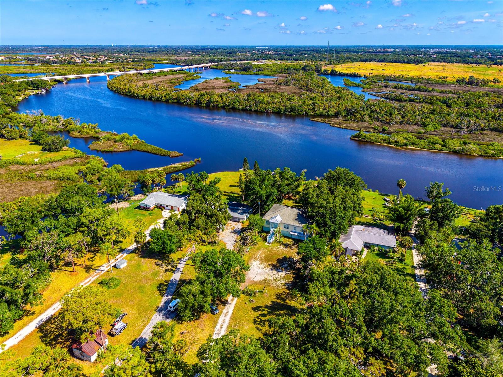 Located at the end of a long private driveway, this rare waterfront offering presents a truly unique opportunity along the banks of the Manatee River. Being offered together as one combined offering, these four separately parceled properties total just over 7 acres, with each parcel featuring approximately 100 feet of frontage on Upper Manatee River Road. Opportunities to acquire this much contiguous waterfront acreage under single ownership are becoming increasingly difficult to find.

The property includes four existing residences with a variety of uses and possibilities. Two homes are currently leased, providing immediate income potential, one residence is ready for a major renovation or replacement, and the fourth is a two-story Key West-style home with solid character and room for a new owner’s vision. The largest home also includes a guest cottage and large storage barn, ideal for car collectors, RV storage, workshop space, or additional flexibility rarely found on waterfront property. With no deed restrictions, the possibilities here are extensive.

Deep water access to the Manatee River, combined with acreage of this size and a location just north of the rapidly expanding Lakewood Ranch area, creates a compelling opportunity for a family compound, private estate, redevelopment project, or long-term waterfront investment. Large waterfront acreage is rare. Four contiguous riverfront parcels offered together is even more uncommon.