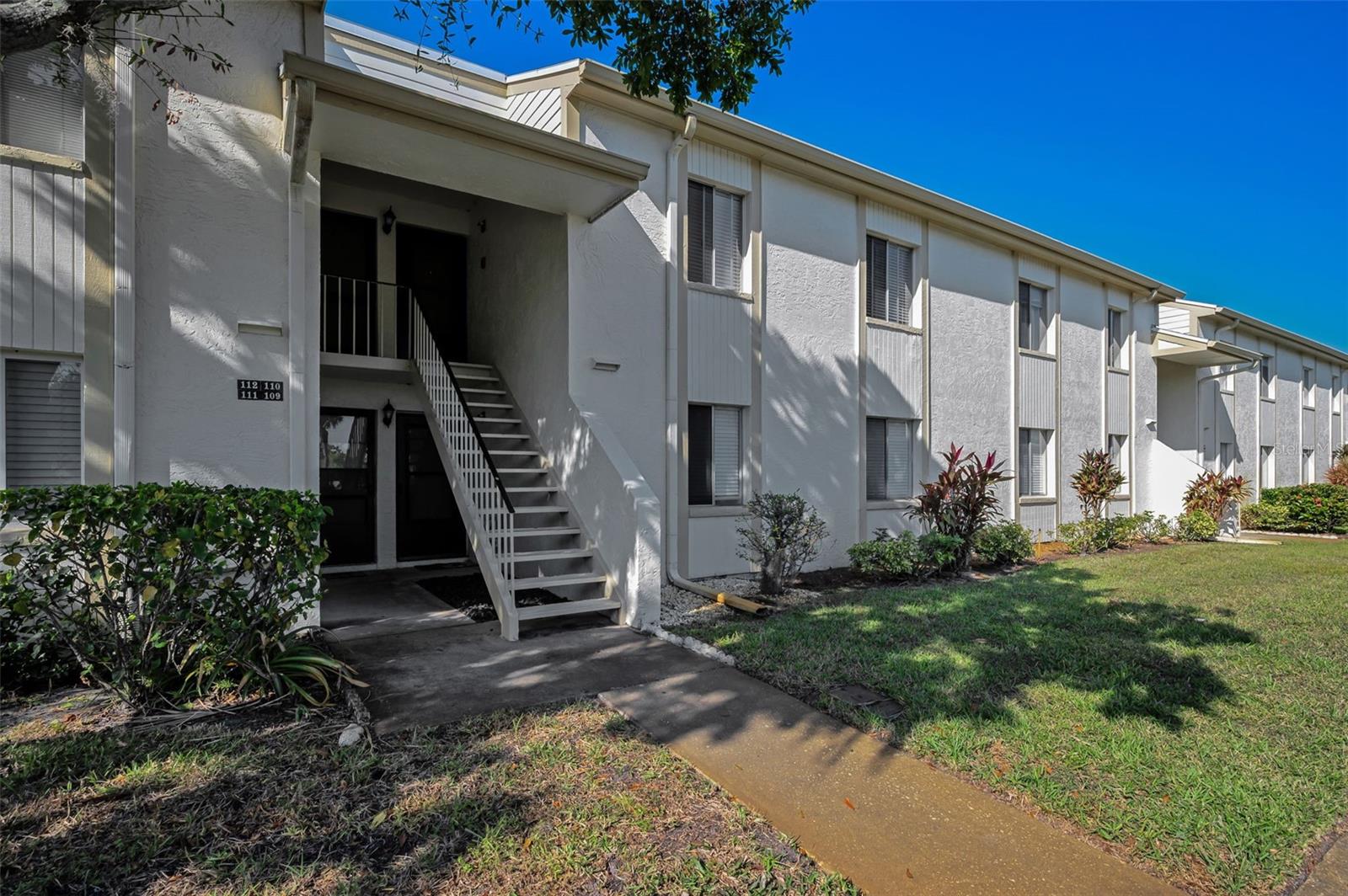 Welcome to a condo that feels like home the moment you step inside. Beautifully updated and meticulously maintained in the highly sought-after guard-gated East Lake Woodlands community. Light, bright, crisp, and spotless, this 2-bedroom, 2-bath residence is truly move-in ready. The kitchen is the centerpiece of the home, featuring solid wood cabinetry, quartz countertops, stainless steel appliances, porcelain tile flooring, a spacious pantry, breakfast bar, coffee bar area, and an updated tray ceiling with LED lighting that adds a modern, elevated feel. Gorgeous laminate flooring flows throughout the main living areas, creating a seamless and stylish design. The open-concept living and dining space leads to a private screened balcony overlooking a peaceful, natural greenspace. The primary suite offers dual walk-in closets and a beautifully updated en-suite bath with quartz countertops. The secondary bedroom is comfortably sized, and the guest bath is clean, bright, and tastefully updated. Additional features include a 2023 LG front-load washer and dryer, updated lighting and fixtures throughout, and a roof that was replaced approximately two years ago. The covered carport is conveniently located as the first space closest to the building entrance. Every detail reflects pride of ownership and consistent care. Residents of East Lake Woodlands appreciate the natural beauty, walkable setting, and convenient access to all that Tampa Bay has to offer. Community amenities include a heated pool, scenic walking paths, and an optional membership to Ardea Country Club with championship golf, tennis, pickleball, fitness, resort-style pools, dining, and year-round activities. Ideally located just minutes from Tampa International Airport, Gulf beaches, bike trails, parks, shopping, Westfield Countryside Mall, restaurants, and the charming downtowns of Dunedin, Tarpon Springs, and Safety Harbor. No flood insurance required (Flood Zone X500). Monthly dues include exterior maintenance, cable, internet, water, sewer, trash, and roof maintenance. Clean, updated, and move-in ready, this home stands out for its warmth, condition, and effortless livability—an opportunity buyers immediately recognize and appreciate.