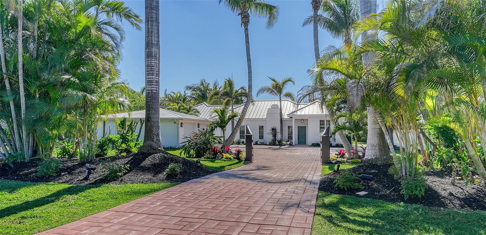 A must see on the north-end of Longboat Key! It even has a private deeded path to the beach! Often called a Coastal Oasis due to its ability to transport you immediately to island time! This charming completely updated three bedroom, three bath home, with a separate air-conditioned, two-car garage is the perfect beach getaway. It is located on a large, tropically landscaped lot with a beautiful private outdoor living area, just steps to the white sandy beaches. Completely rebuilt from the studs up in 2018, it has new kitchen and baths, wiring, plumbing, air-conditioning, hurricane impact windows and doors, Hardi-plank siding, and metal roof. The open floor plan includes a living room, dining area, reading or office area and kitchen with exposed wood beam ceilings, gas fireplace and porcelain wood plank style flooring. The kitchen is outfitted with top-of-the-line appliances including a Wolf gas range and SubZero refrigerator, marble countertops, Shaker style wood cabinets, farm sink, porcelain tile backsplash, LED lighting and a large waterfall island with seating. The bathrooms have specially selected marble and glass tiles, vanities and sinks, plumbing fixtures, and lighting. The primary bedroom suite includes a walk-in closet and a large bathroom with double sinks, Kohler soaking tub and glass tile shower. French doors in the back open out to a large limestone patio with a refreshing heated, saltwater pool and spa and pergola-covered dining area with gas grille. A perfect place for entertaining or lounging in the sun.  An ideal yard for pet owners and kids. Close to restaurants and shopping in the Longboat Village and near Cannon’s marina. Also provides great rental opportunities.