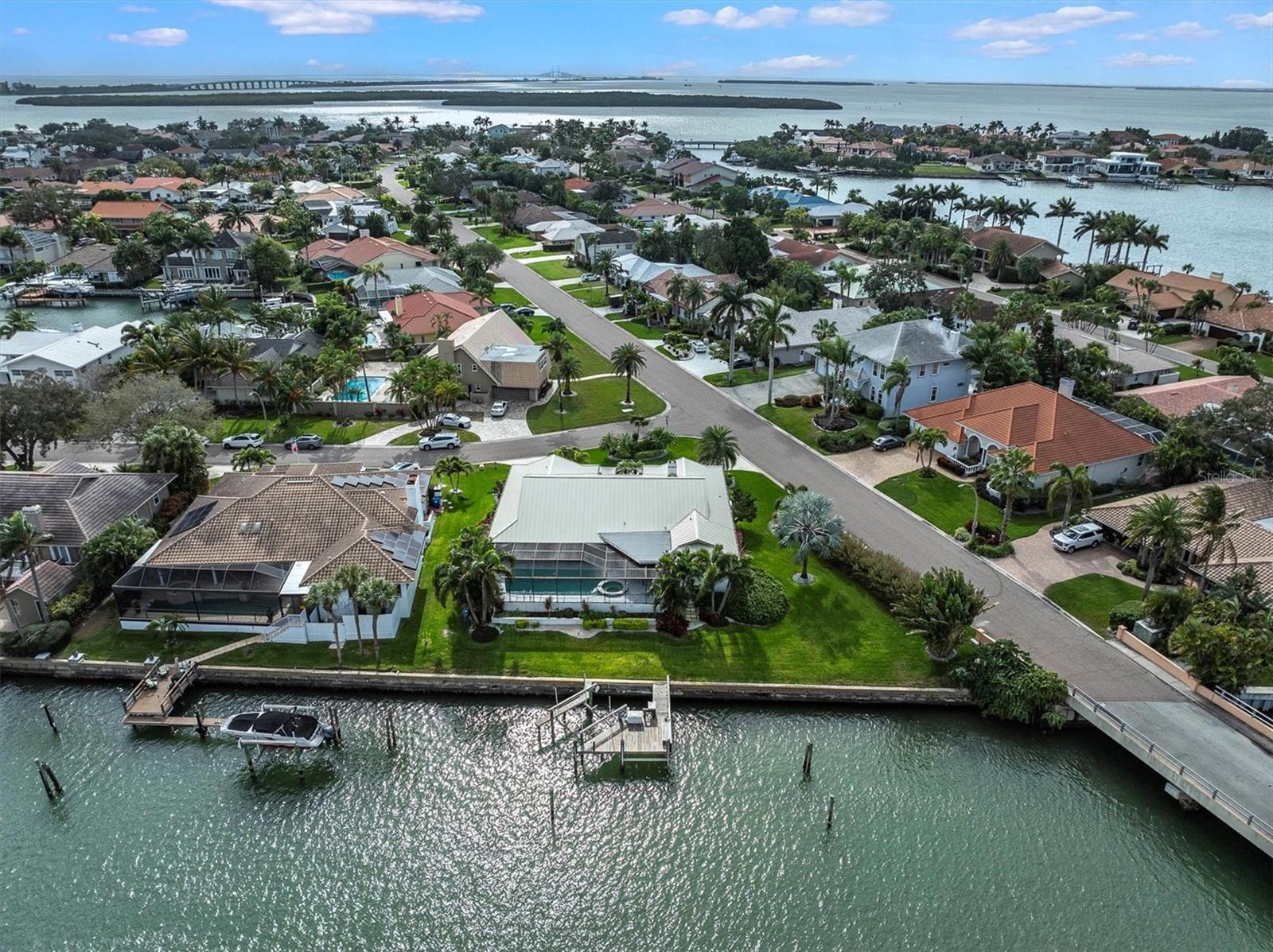 Welcome to Bayway Isles! This waterfront home boasts four bedrooms, three baths, and a stunning renovated interior.
The contemporary transitional style creates an open floor plan, seamlessly connecting the family room, kitchen, poolside, and dock overlooking the canal leading to Tampa Bay. 
The screened lanai pool area adds to the allure, creating an ideal shaded space for dining and lounging. A pass-through window from the kitchen facilitates easy transfer of food for alfresco dining, blending convenience with charming outdoor dining. 
Outside, you’ll find a new metal roof, hurricane windows, lush landscaping, circle driveway and oversized two-car garage! Bayway Isles is an exclusive guard-gated island community. Residents enjoy close proximity to pristine beaches, and the convenience of being just a short drive from the vibrant cultural scene and amenities of downtown St. Petersburg.