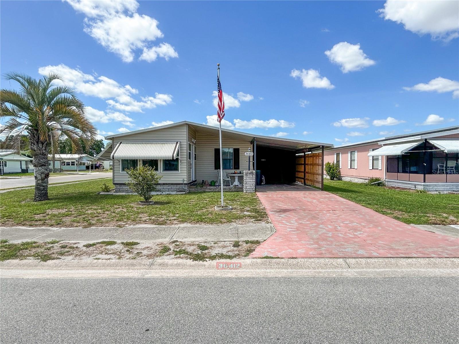 Ultimate Florida Living! Fully Updated and Furnished Home with Bonus Florida Room. Escape the winter blues and embrace the ultimate sunshine lifestyle in this beautifully maintained, move-in-ready double-wide manufactured home. Located in the highly desirable Oaks Royal III community, you enjoy the rare and valuable benefit of owning your own land with absolutely no lot rent. Your journey begins in a massive screened porch that offers a breezy oasis for outdoor relaxation before welcoming you into a bright, open floor plan with durable laminate flooring and brand-new waterproof vinyl tile. The modern kitchen shines with solid oak countertops, a fresh backsplash, stainless steel appliances, a newer dishwasher and large closet pantries. Expansive sliding doors lead you to a sun-drenched, fan-cooled, front-facing Florida room that provides incredible bonus square footage for a home office, hobby area, or entertaining guests.Retreat to the private master suite, a peaceful haven boasting plush Berber carpeting, a cooling ceiling fan, a huge walk-in closet, and a luxurious en suite bathroom complete with dual sinks and a modern step-in shower. The generous second bedroom also features its own walk-in closet and easy access to the pristine main bathroom with its tub-and-shower combination. Storage is easy thanks to a dedicated laundry room with practical built-in shelving, a newer washer and dryer, a new hot water heater installed in 2024, and an updated electrical panel. Best of all, the air conditioning unit and all ductwork were fully replaced in 2022 to give you total peace of mind and keep you cool all year long.This active, friendly community elevates your everyday life with resort-style amenities that make you feel like you are always on vacation. You can spend your days enjoying the sparkling heated pool, the relaxing hot tub, and the vibrant clubhouse. The neighborhood also offers competitive shuffleboard courts, pristine paved sidewalks perfect for energetic morning exercise, convenient parking lots, storage buildings, and beautiful memorials. Schedule your appointment today!