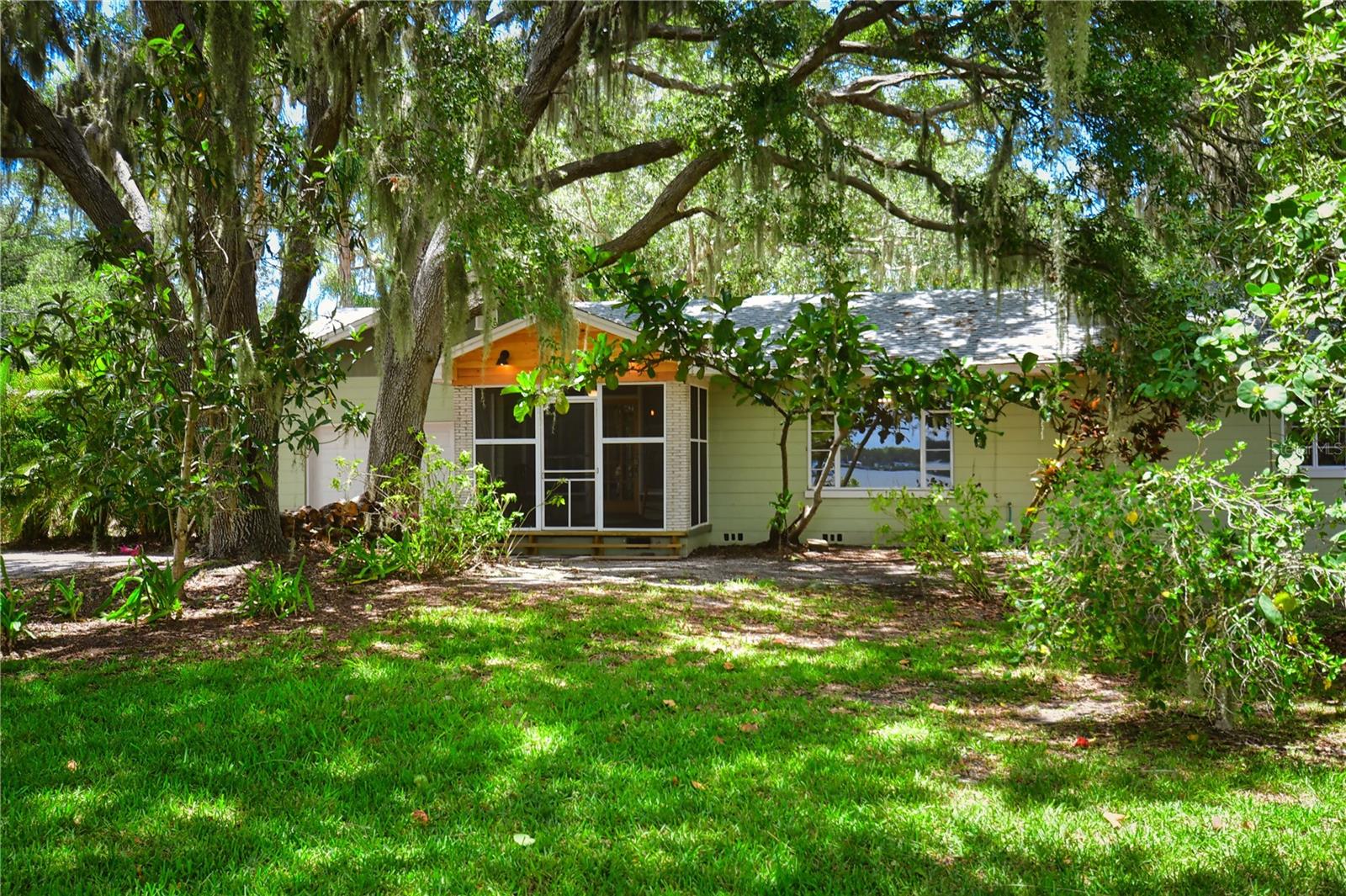 Welcome to Old Florida! Stepping onto the screened porch is like stepping through a portal to the past. A simpler place and time, where fireflies dance under the canopy of oaks. Cast a line, or a net, or a kayak out on the still waters of Terra Ceia Bay where the sun rises and sets in a golden glow.  Build your own private dock for your boat or your Adirondack Chairs right on the Bay! You can just imagine marshmallows over the firepit and a big swing hanging from low mossy branches, overlooking over 100 feet of private natural waterfront. The charming cottage sits back on the land, providing a large front garden with Florida native plants. Inside the cottage, refinished wood floors lead you from one room to the next. From the large Dining Room, French doors open to the Living Room with original wood burning fireplace and a picture window overlooking the Bay. Warm butcherblock countertops over white cabinets give this kitchen a nostalgic feel with plenty of counter space and storage space. The Florida Room stretches across the back of the home, overlooking a big back yard surrounded by lush landscaping. One bedroom overlooks the back yard and has an ensuite bath with shower. The second, and larger of the two bedrooms, has a picture window with panoramic water views. A second full bath with soaking tub is just of the hallway. Nestled between the Terra Ceia Aquatic Preserve and the Terra Ceia Preserve State Park, you will be surrounded by natural wonders and winding trails, while being only 20 minutes away from Downtown St. Petersburg or Bradenton.