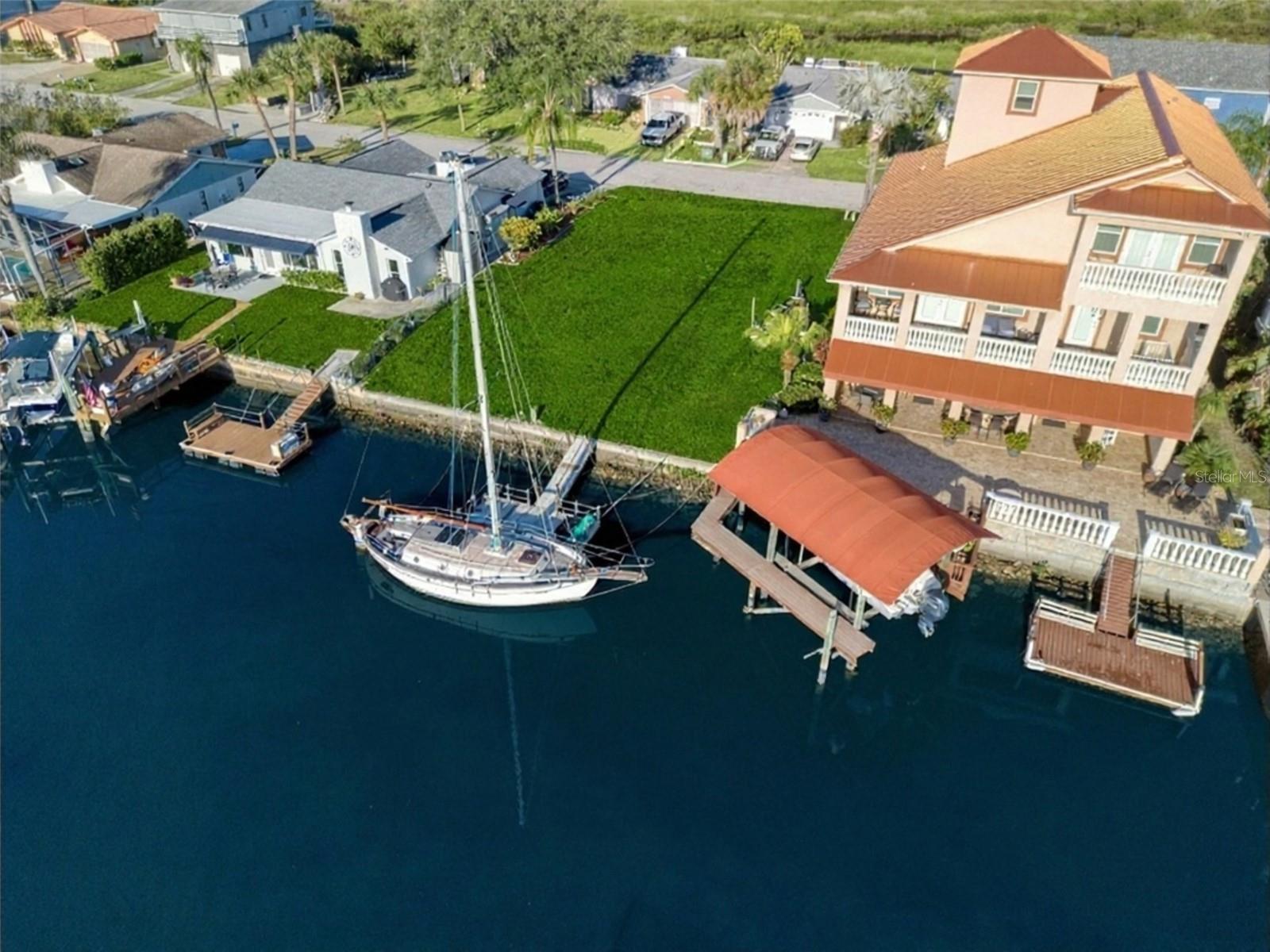 If you are looking for a wide and deep waterfront canal lot, with direct access to the open Gulf just around the corner, this is the lot for you. There is so much wildlife both on land and sea.  If you love immersing yourself in nature, boating, kayaking or fishing, this lot is perfect. The lot boasts a sixty foot sea wall and floating dock and is minutes to open water. Arguably the best lot located in the desirable Sea Pines community, this ready to build lot is situated at the end of a quiet cul-de-sac with easy access to the Gulf with no bridges and deep water for the possibility of all hours access. This west facing property offers both privacy and breathtaking sunset views over the water. Whether you envision building a contemporary waterfront estate or a laid-back coastal escape, this Sea Pines community offers the perfect canvas for your next chapter of Florida living. Underground utilities are already in place. The community offers a neighborhood clubhouse, boat ramp, and water front park with walking trails. Located close to US Highway 19, with shopping, restaurants, beaches, and all amenities, makes this lot the ultimate Florida waterfront lifestyle location.