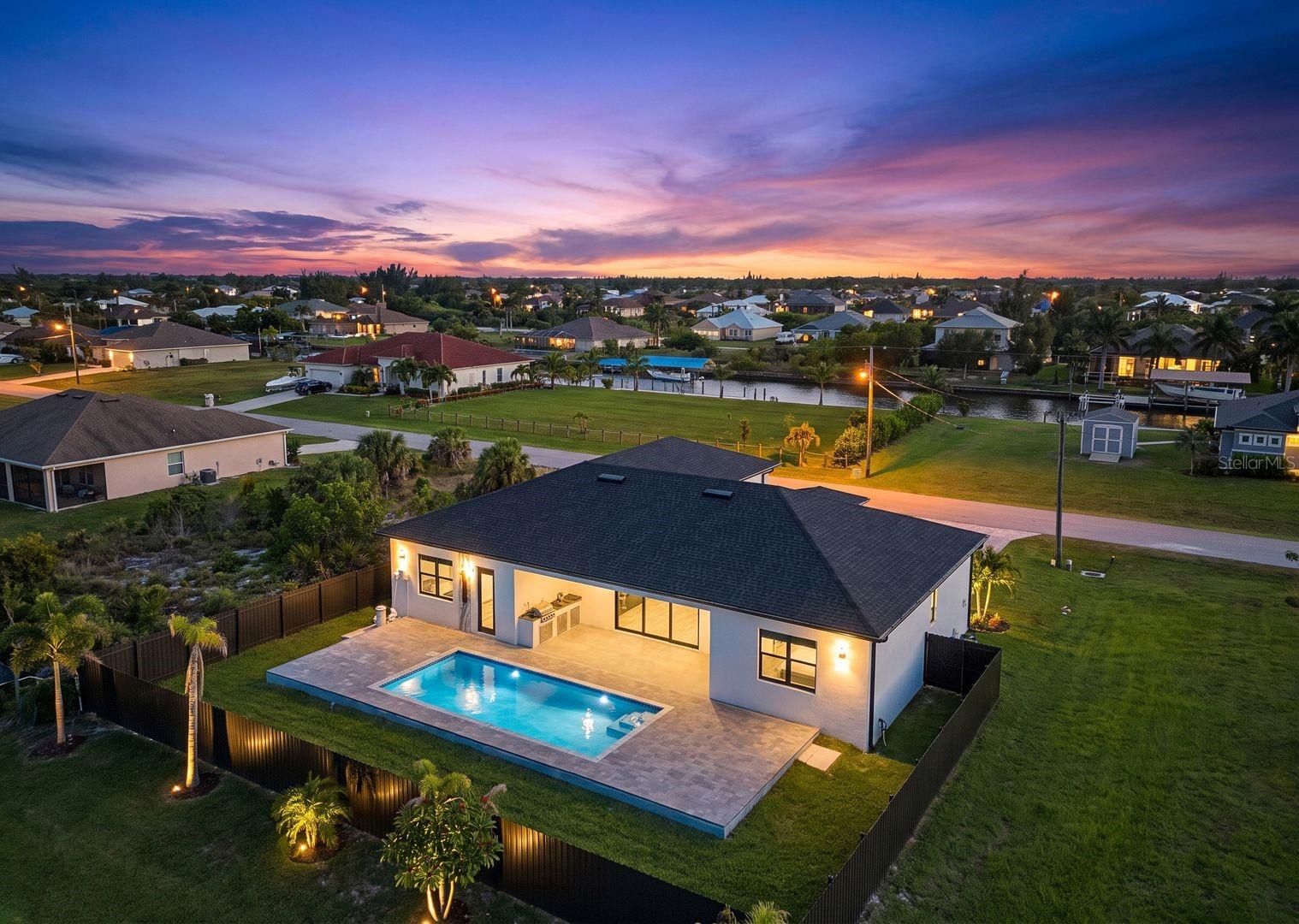 Located in the sought-after South Gulf Cove community, this custom-built 4-bedroom, 3-bathroom home offers 2,349 square feet of modern living space with high-quality finishes and a thoughtfully designed layout. Tile flooring extends throughout the home, while impact-resistant windows and doors provide peace of mind and energy efficiency. The open-concept kitchen is designed for both function and style, featuring custom cabinetry, a built-in microwave, shiplap detailing on the oversized island, and a built-in bar that flows seamlessly into the main living areas, making entertaining effortless. The split-bedroom floor plan includes a spacious primary suite with a spa-inspired bathroom featuring dual vanities, a soaking tub, and a walk-in shower with multiple shower heads. A private guest suite with its own en-suite bathroom and direct access to the pool offers added flexibility for guests or multi-generational living. The backyard is designed for enjoying the Florida lifestyle with a private pool, built-in outdoor BBQ area, and a fully fenced yard offering both privacy and plenty of room to relax or entertain. A side-load garage completes the home's custom exterior and enhances its curb appeal. South Gulf Cove is known for its waterfront lifestyle, community parks, walking paths, public boat ramps, and convenient access to Charlotte Harbor, Gulf beaches, golf courses, shopping, dining, and all that Southwest Florida has to give.