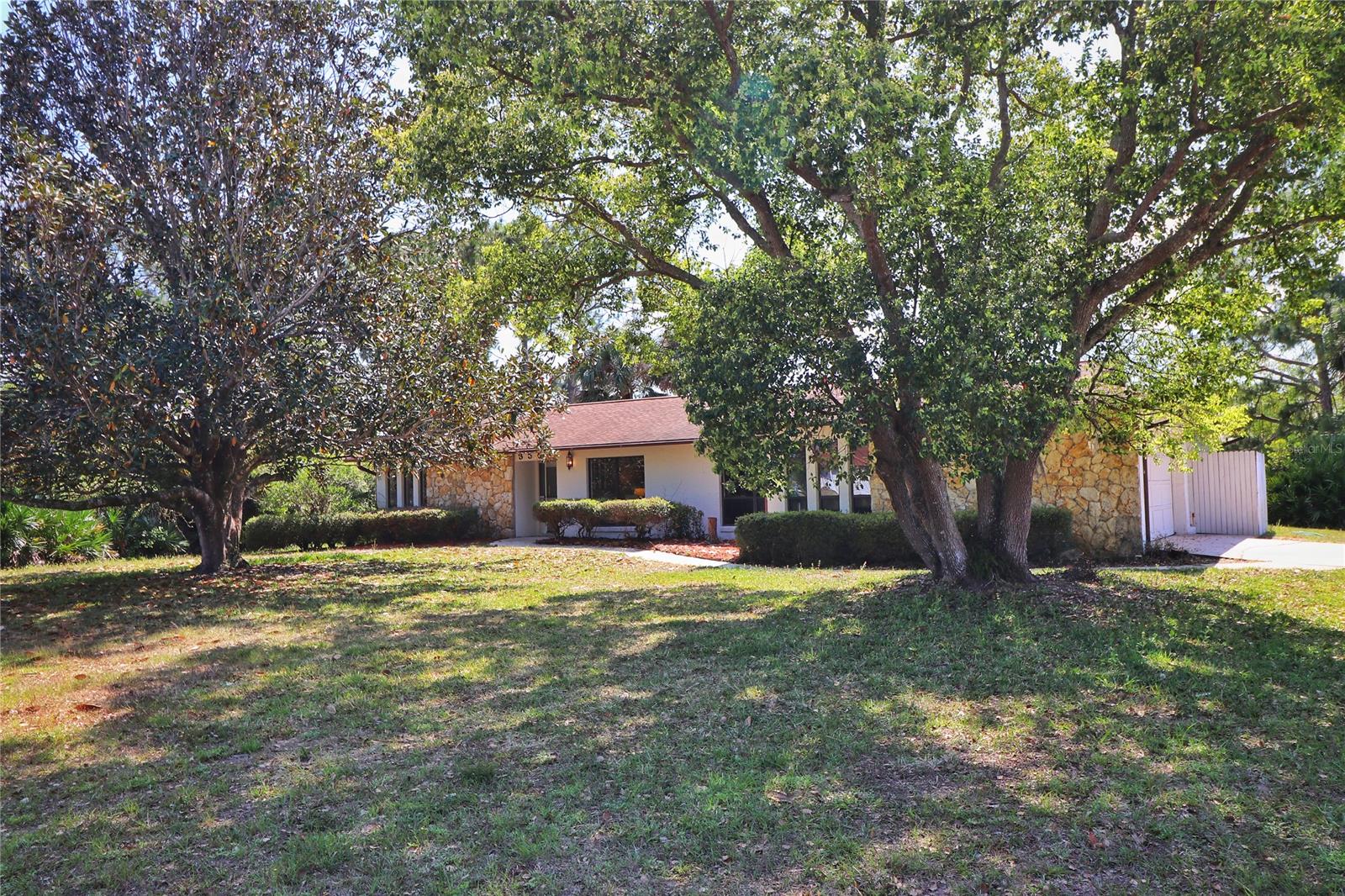 3/2 ranch home on 1 acre. A Huge magnolia tree graces the front yard of This split bedroom plan, which has laminate wood-look easy care flooring and tile throughout. Featuring; A rock fireplace in the great room, and spacious, open living/dining/family room. The kitchen has an open pass through counter to the living area with bar stools to sit and chat while someone cooks or as a buffet bar, 2 pantries for the kitchen and ample cabinets. Room for a small eat in cafe table in the kitchen by the window. 2 car oversized garage with laundry in garage and built in cabinetry, 22x22. In addition, there is a one car covered carport and a 11x10 storage shed on the garage side entrance. You can park RV's, boats on trailers and complete the fencing for total lock down privacy.