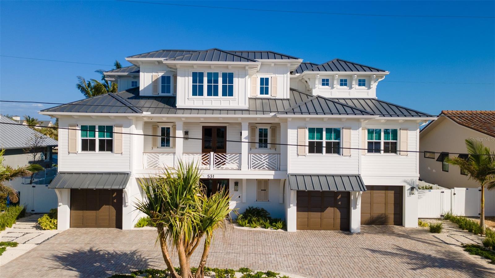 **Custom Coastal Elegant Dream Home on the Grand Canal**  

Discover your slice of paradise on the breathtaking tropical island of Anna Maria. This exquisite custom-built home, completed in 2024, is situated on the island's most sought-after canal, offering direct access to Tampa Bay and the Gulf of America. Its prime southern exposure ensures abundant sunlight and stunning views throughout the day.

This remarkable residence features 5 bedrooms and 5.5 bathrooms, allowing ample space for family and friends. Forget the lengthy wait times for construction or renovations; this home is move-in ready, offering the perfect blend of luxury and convenience.

As you enter, you’ll be drawn to the elegant foyer with French doors that lead to an outdoor kitchen, perfect for entertaining. The gourmet outdoor kitchen is equipped with a Sapphire grill, Memphis pellet grill, Blackstone griddle, and gas burner, all complemented by durable, waterproof HDPE cabinetry and sleek concrete countertops. Adjacent to the outdoor kitchen, a full bath adds convenience for outdoor living.

Step into your personal oasis featuring a 13x39 heated and cooled pool, alongside an extra-large hot tub, all under roof for year-round enjoyment. On cooler evenings, gather around the gas firepit for cozy conversations. Beyond the pool, a 70-foot dock with two boat lifts (20,000 lb. and 10,000 lb.) awaits your aquatic adventures.

Back inside, you’ll find beautiful oak engineered hardwood flooring and stunning wood beams throughout the living spaces. The bar area features an ice machine and mini wine fridge, while the inviting living room includes a fireplace. The chef’s kitchen boasts high-end Thermador appliances, quartz countertops, double sinks, double dishwashers, and a dream-worthy butler's pantry.

The main living floor hosts the luxurious primary bedroom with his and her closets, one guest bedroom, a half bath, and a convenient laundry room. Relax on the front and rear porches, where you can soak in breathtaking views of the sunsets and sunrises.

Venture upstairs to discover three additional bedrooms with vaulted ceilings, two more baths, and a bonus den. The top floor also features an exquisite workspace bathed in natural light, perfect for productivity. Step out onto the upper balcony for morning coffee or evening cocktails, all while enjoying spectacular views of the Grand Canal.

On the ground level, you’ll find two storage rooms, which can serve as additional guest space, a game room, or a workout area. A dedicated fisherman’s dream storage room allows you to keep all your tackle and fishing gear organized.

This home is equipped with a generator, two HVAC units with zoned systems, security system with cameras and a complete home entertainment system, both inside and out, featuring Sonos. Additionally, one side of the garage is prewired for an electric vehicle charger.

No detail has been overlooked in this extraordinary home, epitomizing resort-style living at its finest. Don’t miss this rare opportunity to own a one-of-a-kind property in paradise. **Call today for your private showing!**