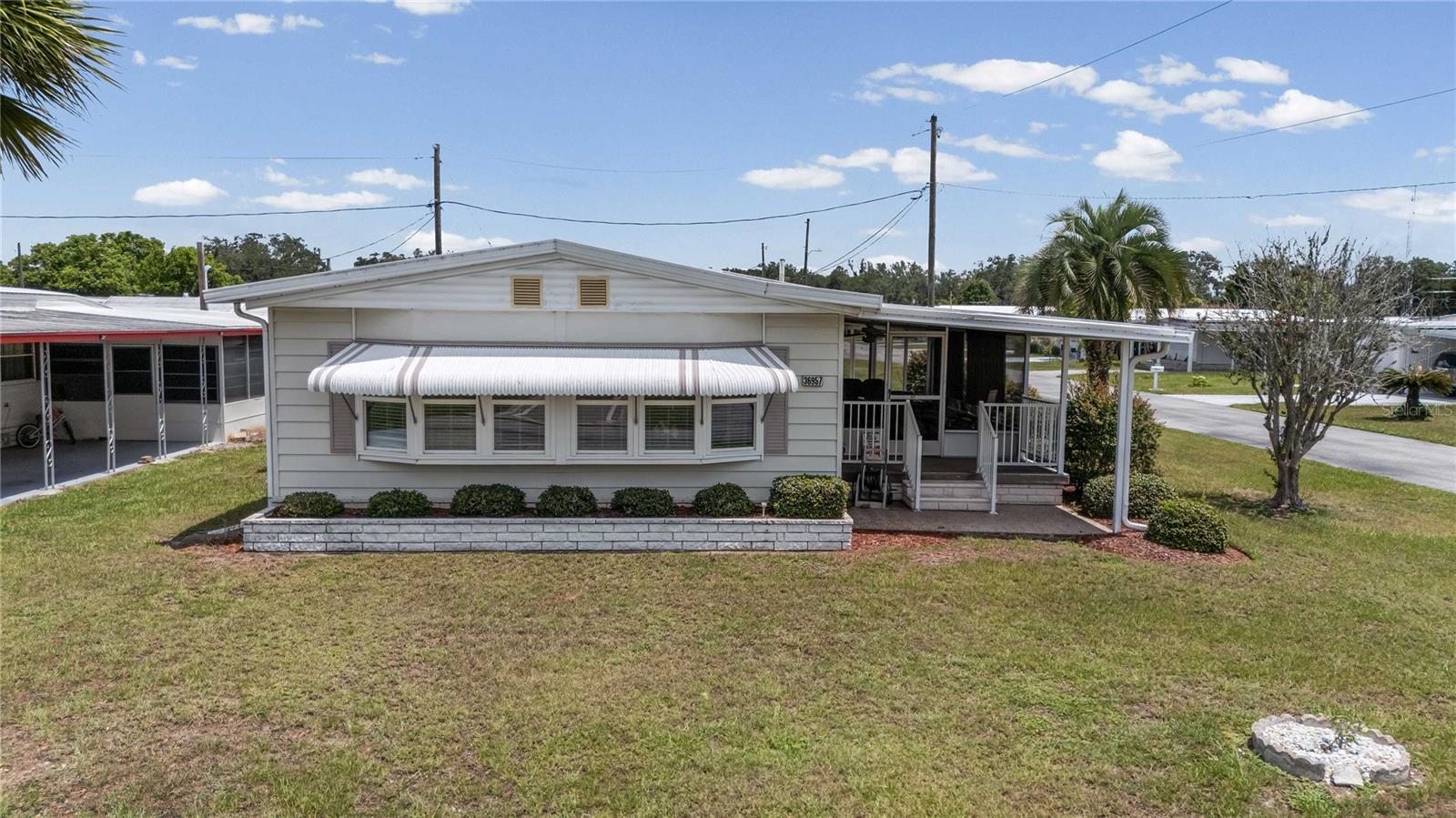 Welcome to sunny Florida living in the highly desirable Betmar Acres, where you own the land and enjoy an active 55+ golf community lifestyle with a low annual fee of just $448! This nicely maintained 2-bedroom, 2-bathroom home is situated on a desirable corner lot and offers important updates including a membrane roof, double-pane windows, and a 2020 A/C system. Inside, you'll find a spacious floor plan featuring two separate living areas. The primary bedroom includes a ceiling fan, built-in closet, and private ensuite bathroom. The guest bedroom offers convenient access to the Jack-and-Jill style guest bath. The family room is open to the kitchen, creating a comfortable gathering space, while the bright living room at the front of the home provides additional room for relaxing and entertaining. The laundry area is conveniently located inside the home. Enjoy Florida's beautiful weather from the welcoming screened room at the front of the home, complete with sliding door access to the interior. The attached storage/golf cart garage at the front of the carport provides plenty of extra storage space. As an added bonus, the nearly new golf cart is included with the sale and has been barely driven! Premium Whisper W7 Halo Series golf cart in excellent condition! less than one year old! Loaded with a maintenance-free lithium battery, luxury diamond-stitched seating, touchscreen display, LED lighting, fold-down rear cargo seat, premium steering wheel, and plenty of storage. Charger and owner's manual included. A stylish, reliable golf cart that's ready to cruise the neighborhood, campground, or golf course! Residents of Betmar Acres enjoy an abundance of amenities, including golf, swimming pools, hot tubs, clubhouses, pickleball, tennis, shuffleboard, bocce ball, and countless social activities. Conveniently located near shopping, restaurants, premier medical facilities, and just a short drive to some of Florida's most beautiful Gulf Coast beaches, this home offers the perfect opportunity for seasonal or year-round living. Come see for yourself what Florida retirement living is all about!